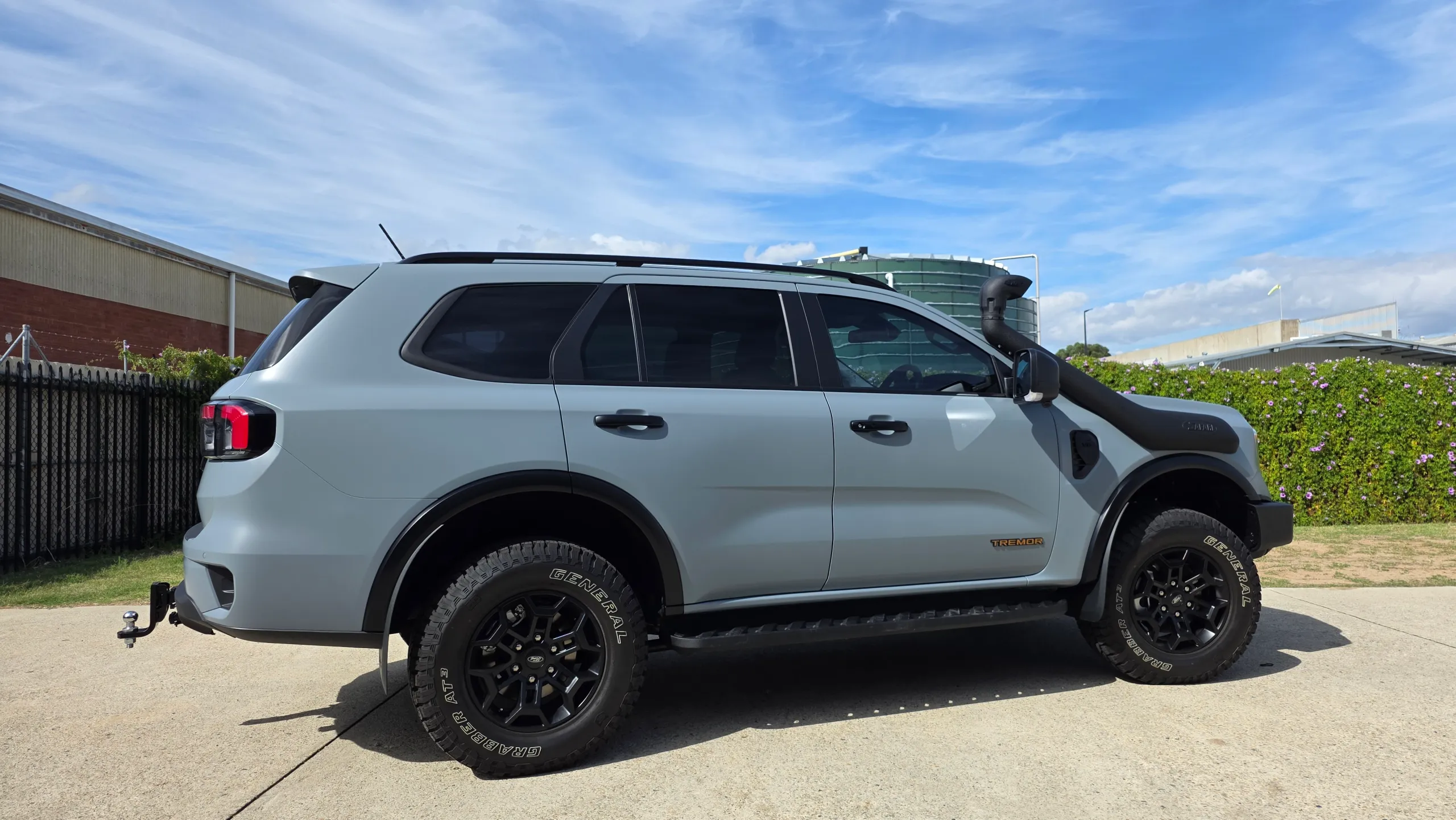 Satin grey Ford Everest Tremor with a snorkel and black wheels outdoors