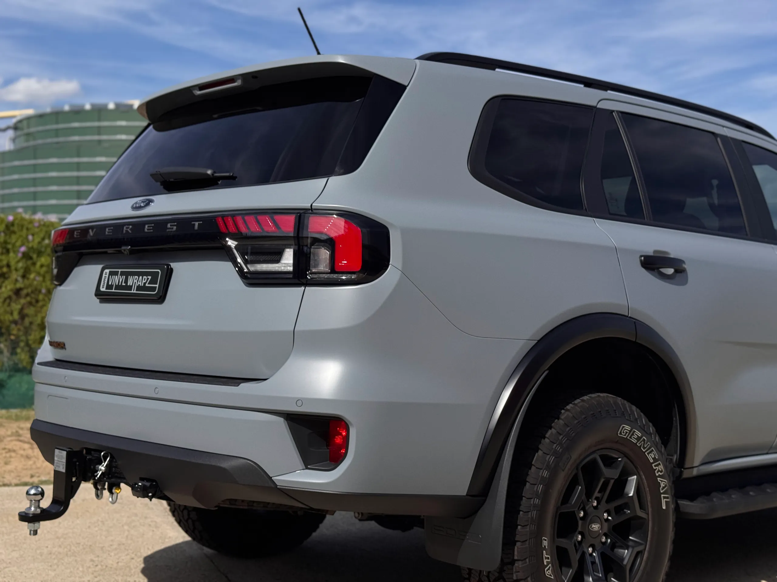 Rear-quarter view of the satin grey Ford Everest Tremor with black wheels