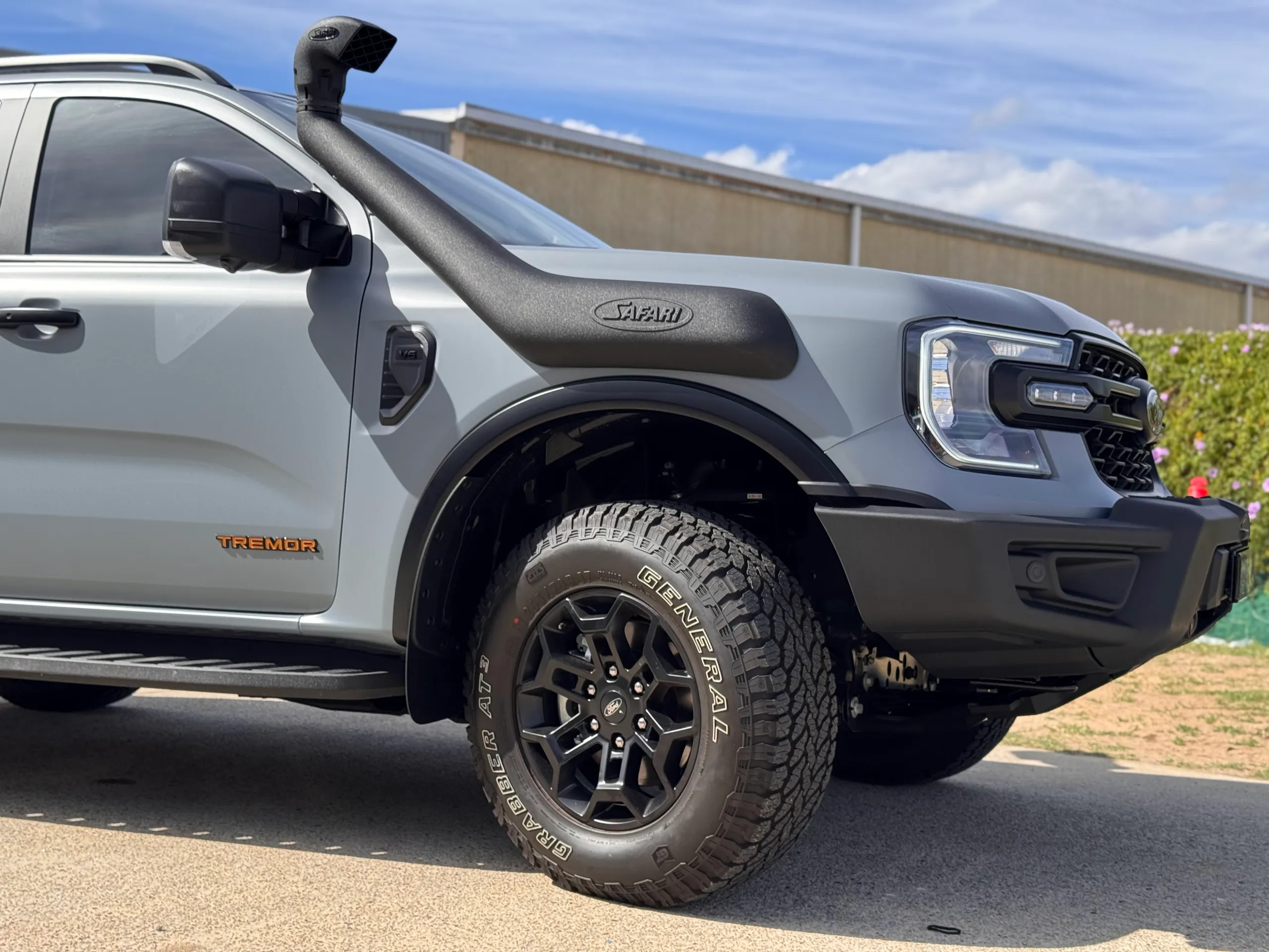 Ford Everest Tremor headlight, snorkel and front wheel beside satin grey bodywork