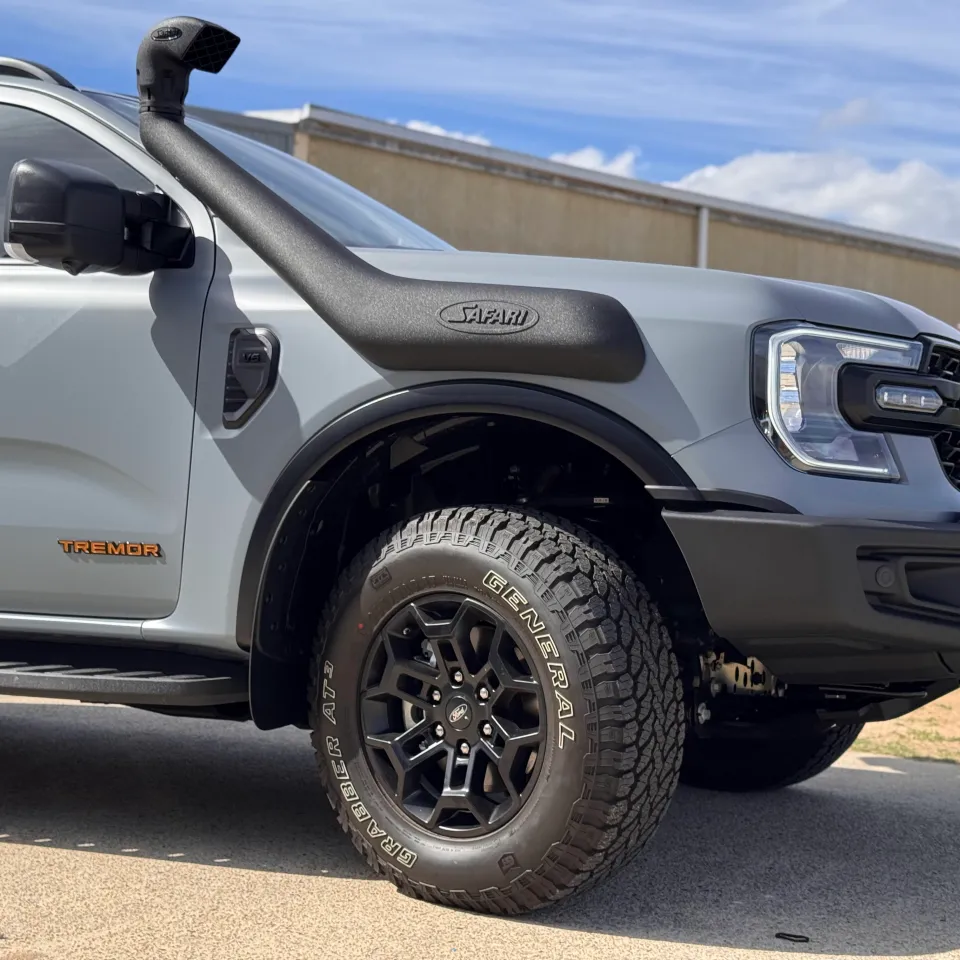 Ford Everest Tremor headlight, snorkel and front wheel beside satin grey bodywork