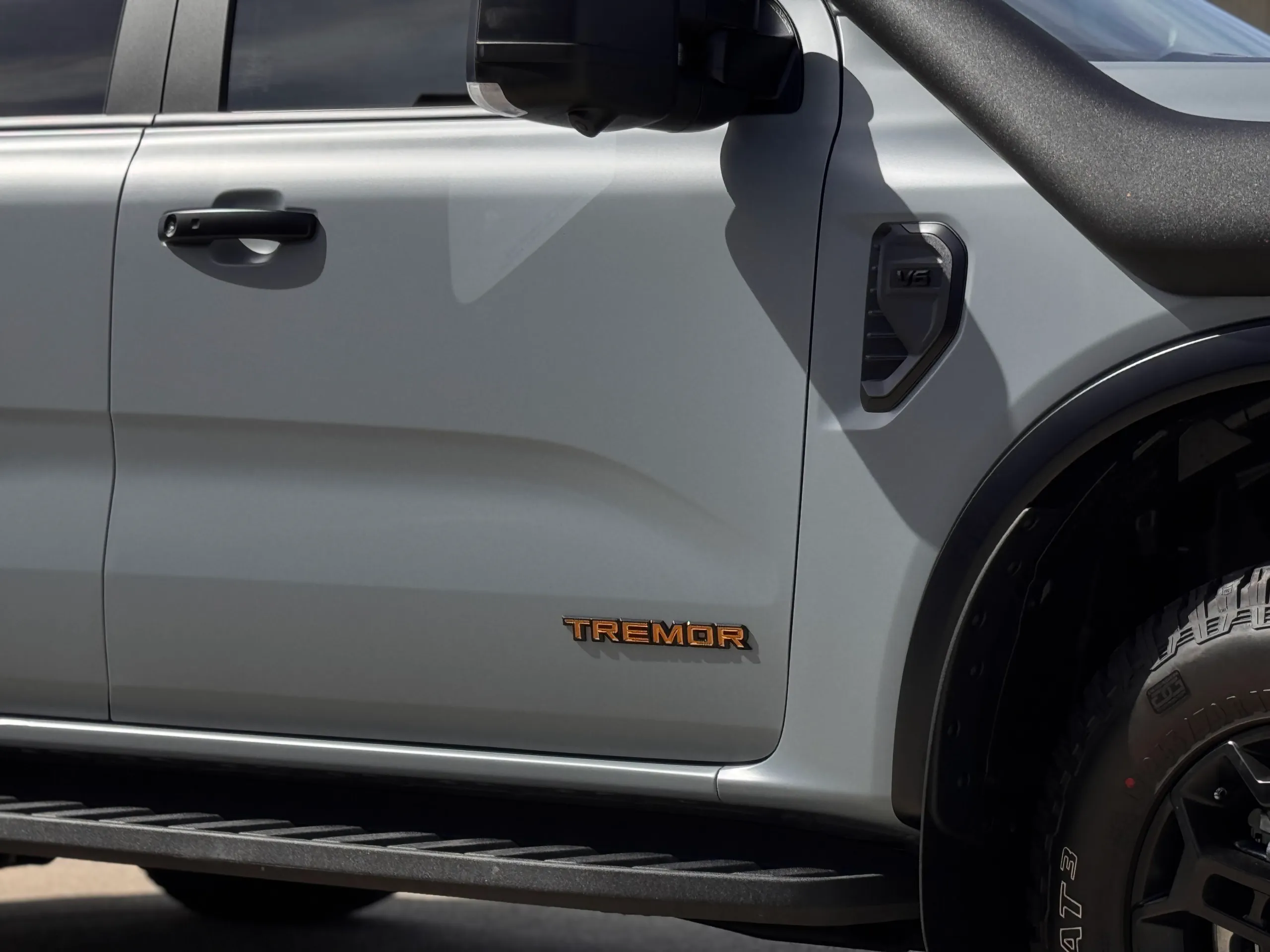 Tremor badge and black door handle on the satin grey Ford Everest front door