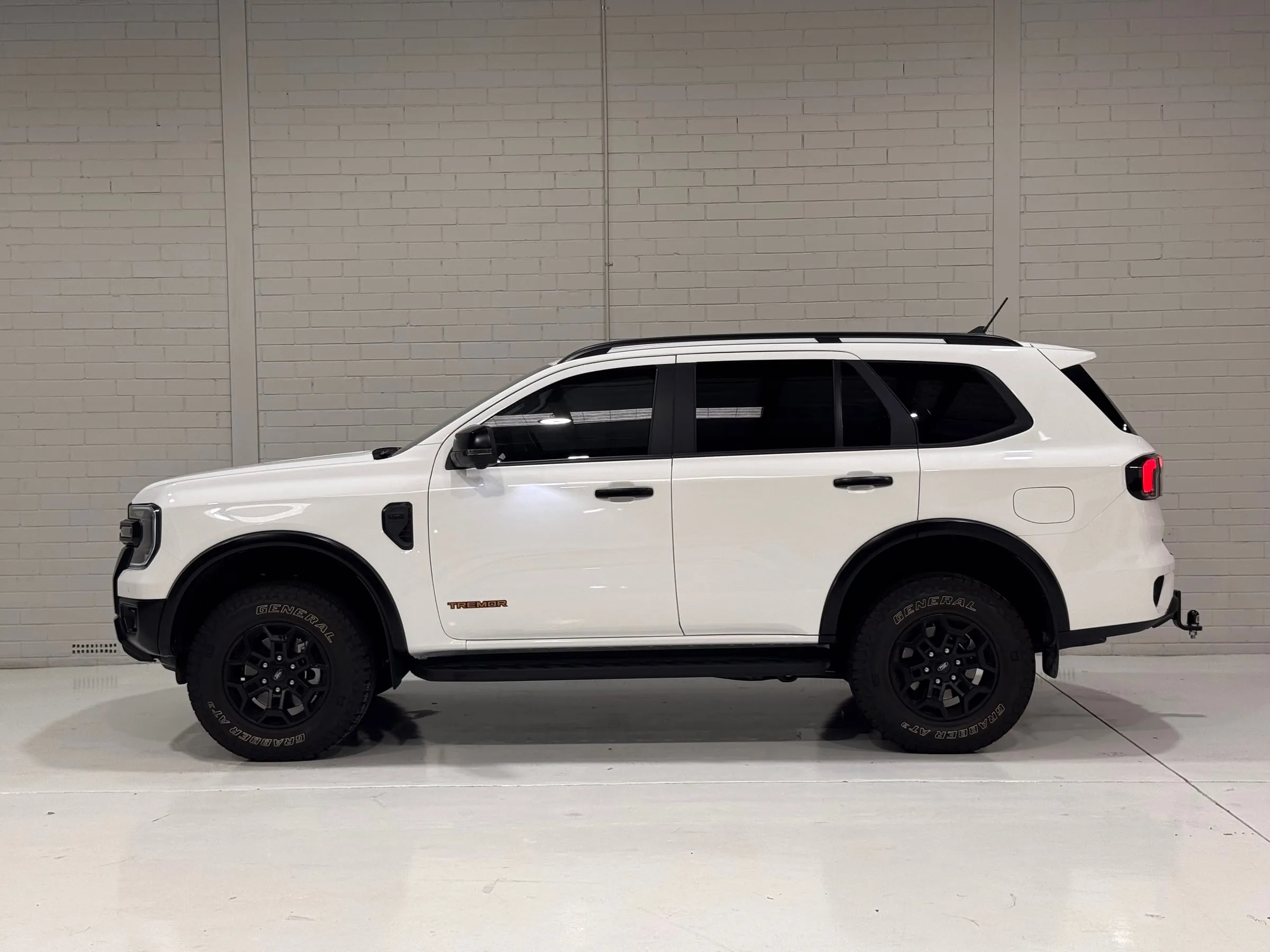 White Ford Everest Tremor with clear paint protection film, roof rails and tow bar, side profile in the Vinyl Wrapz workshop