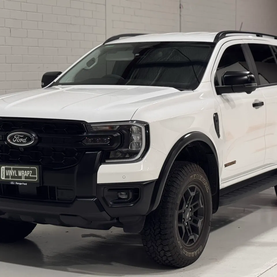 Front and side of a white Ford Everest Tremor, showing the black grille and wheels