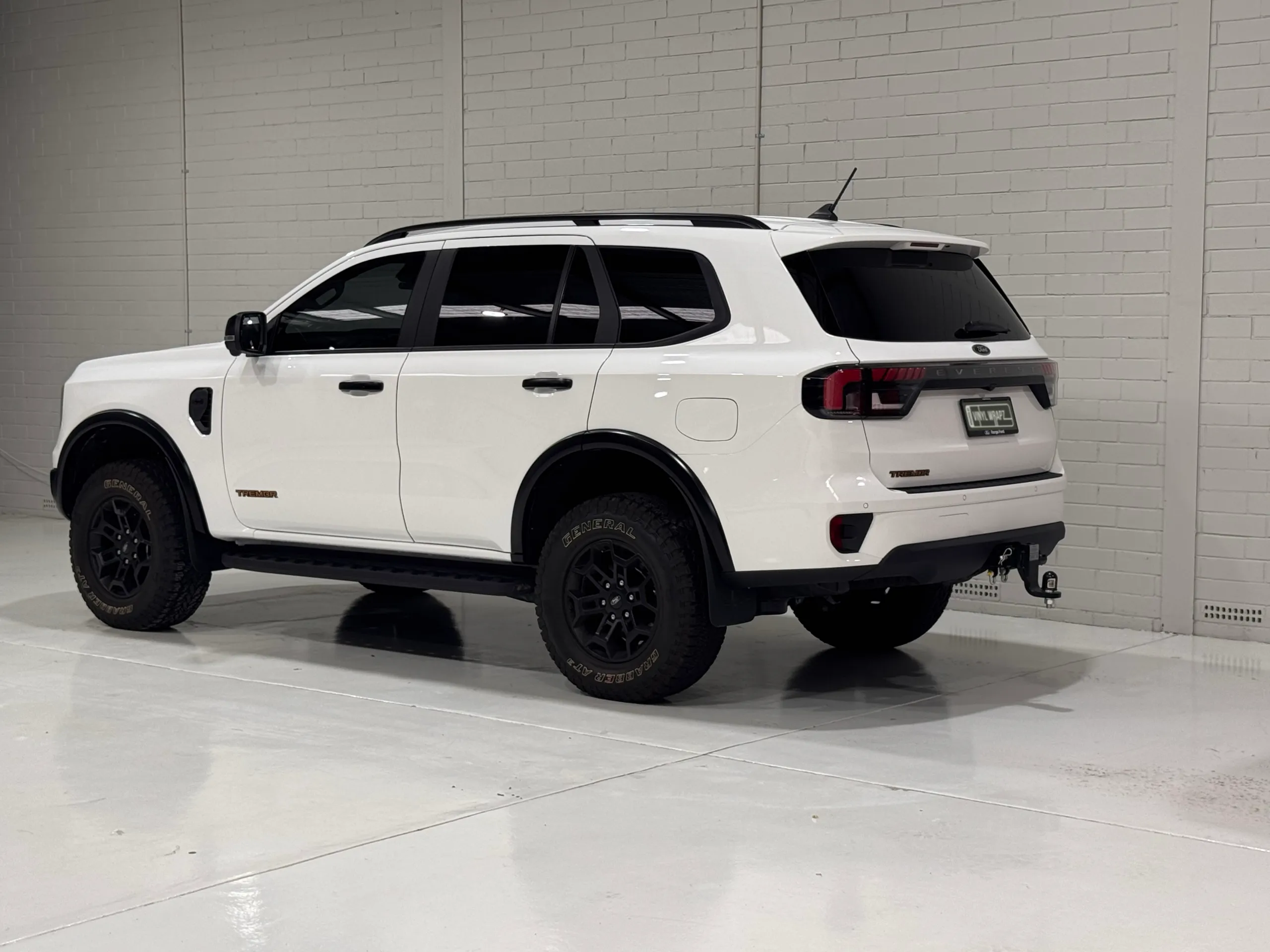 White Ford Everest Tremor viewed from the rear quarter, with black trim and a tow bar