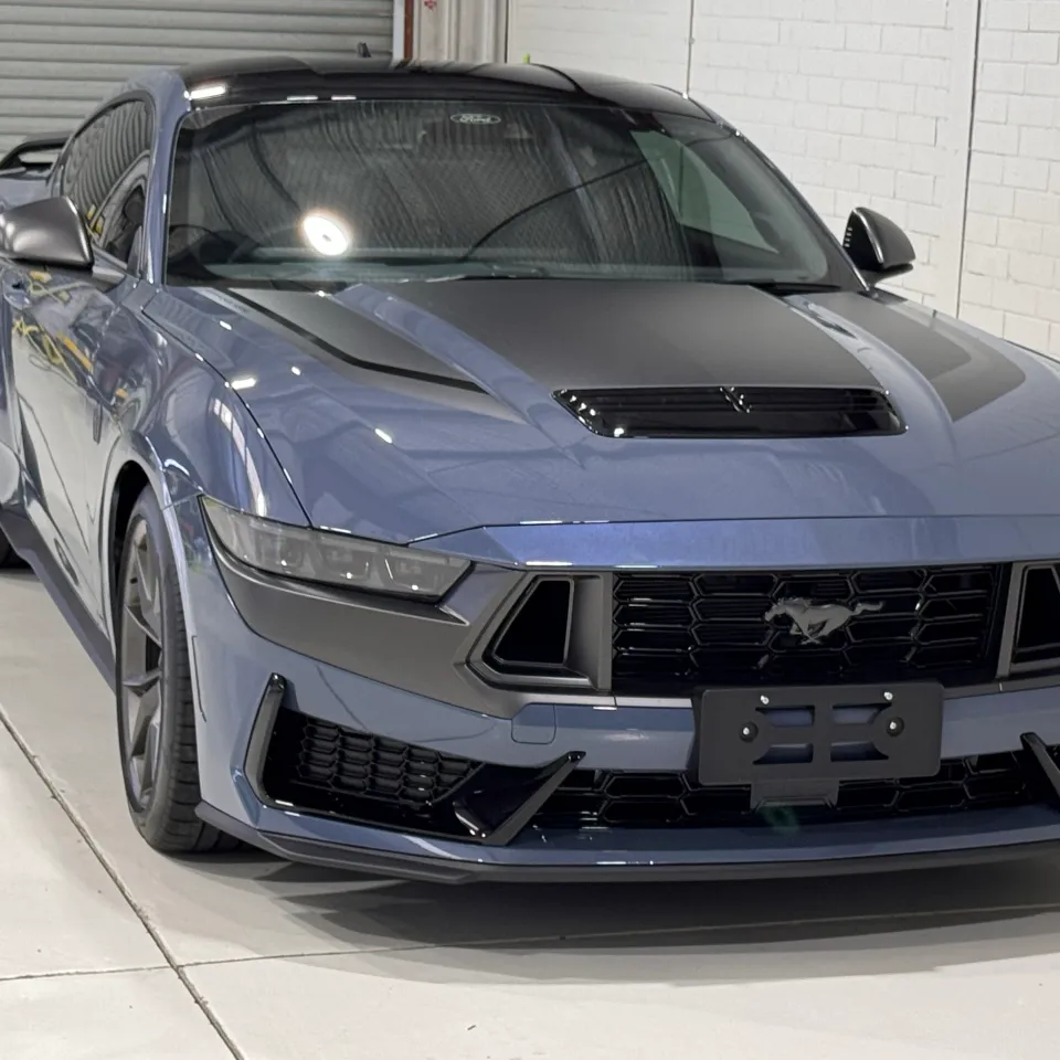 Front-quarter view of a gloss blue-grey Ford Mustang Dark Horse with contrasting bonnet graphics