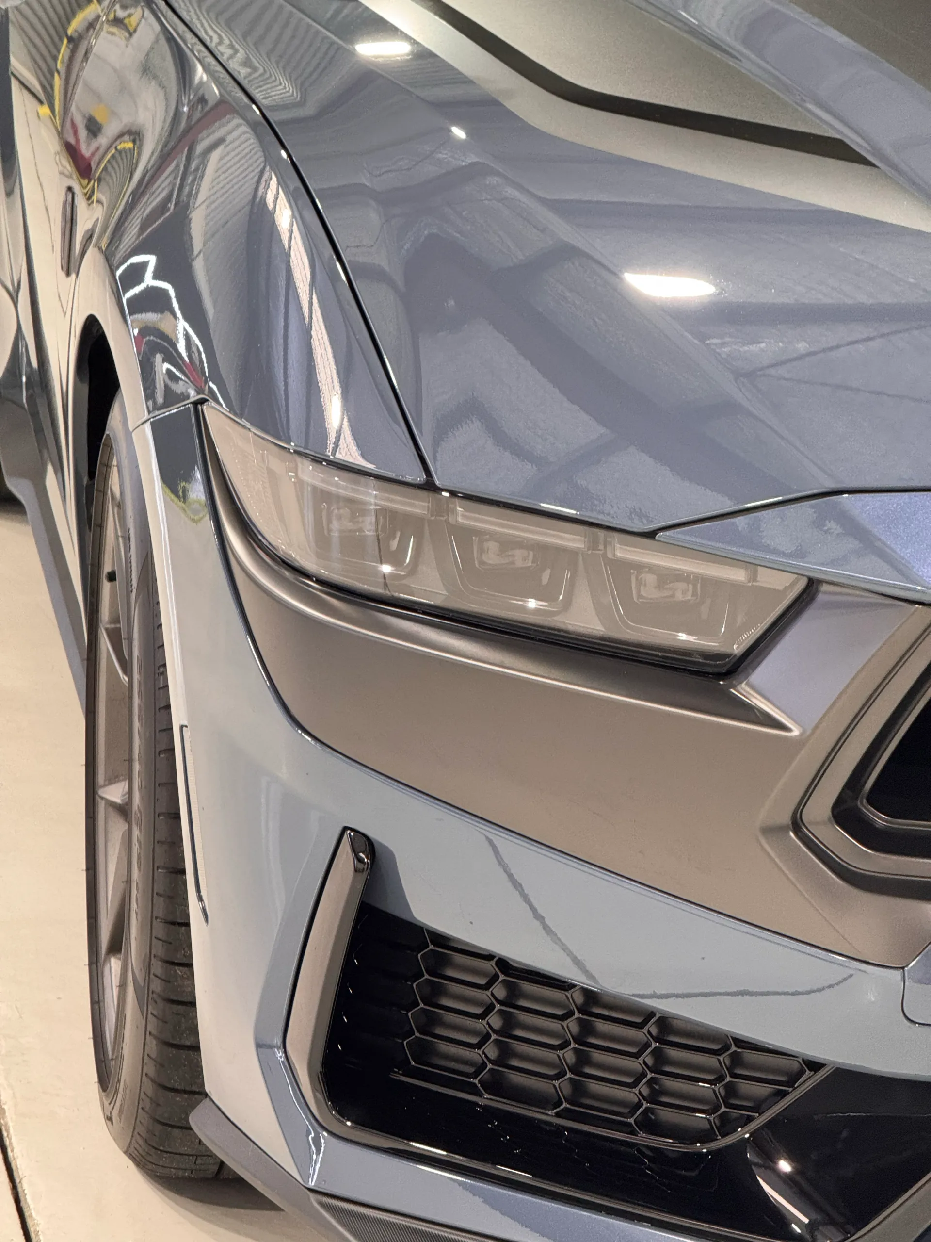 Close-up of the Ford Mustang Dark Horse headlight and dark bumper surround