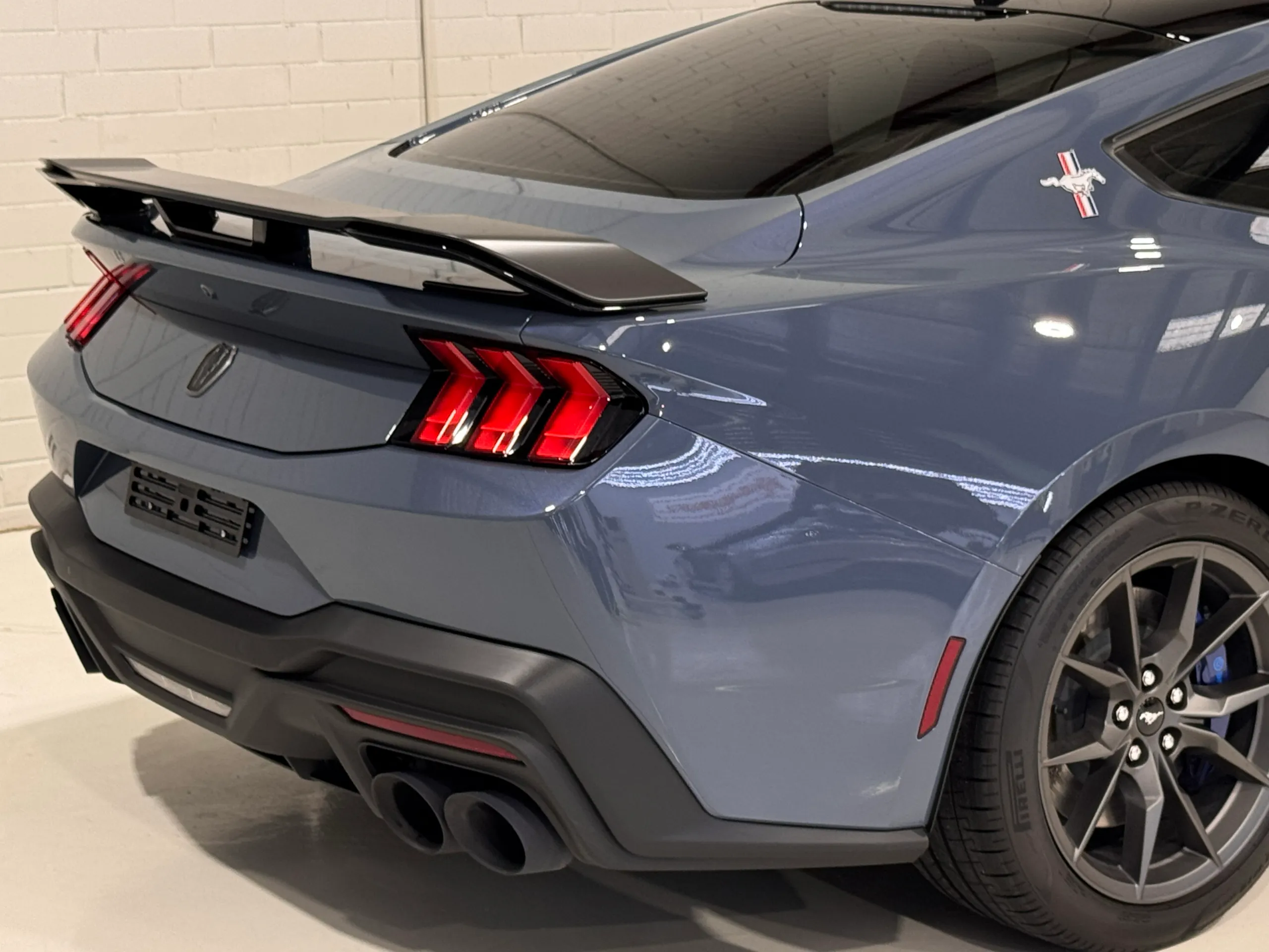 Rear-quarter detail of the gloss blue-grey Ford Mustang Dark Horse in the workshop