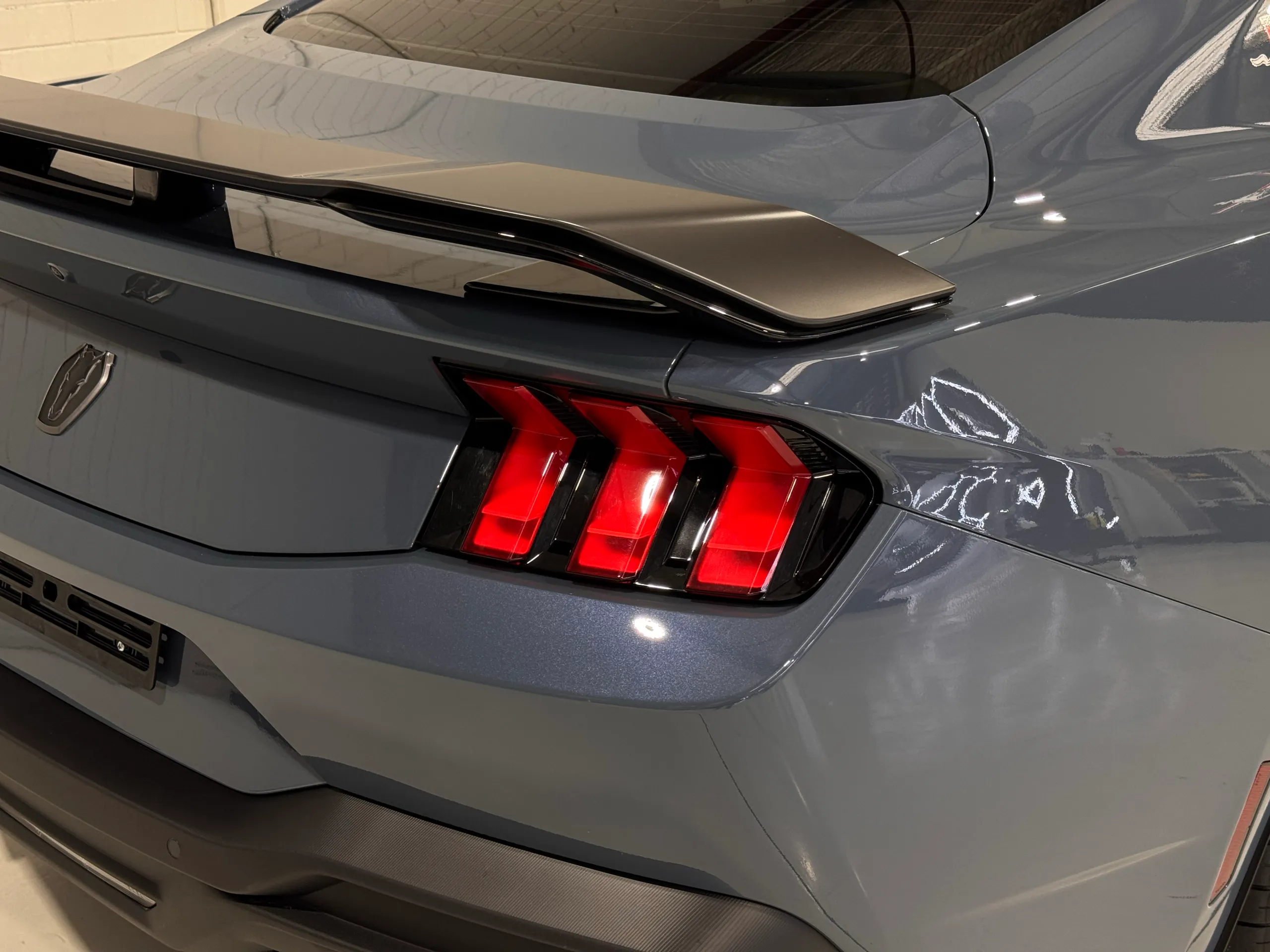 Ford Mustang Dark Horse rear light and spoiler above gloss blue-grey bodywork