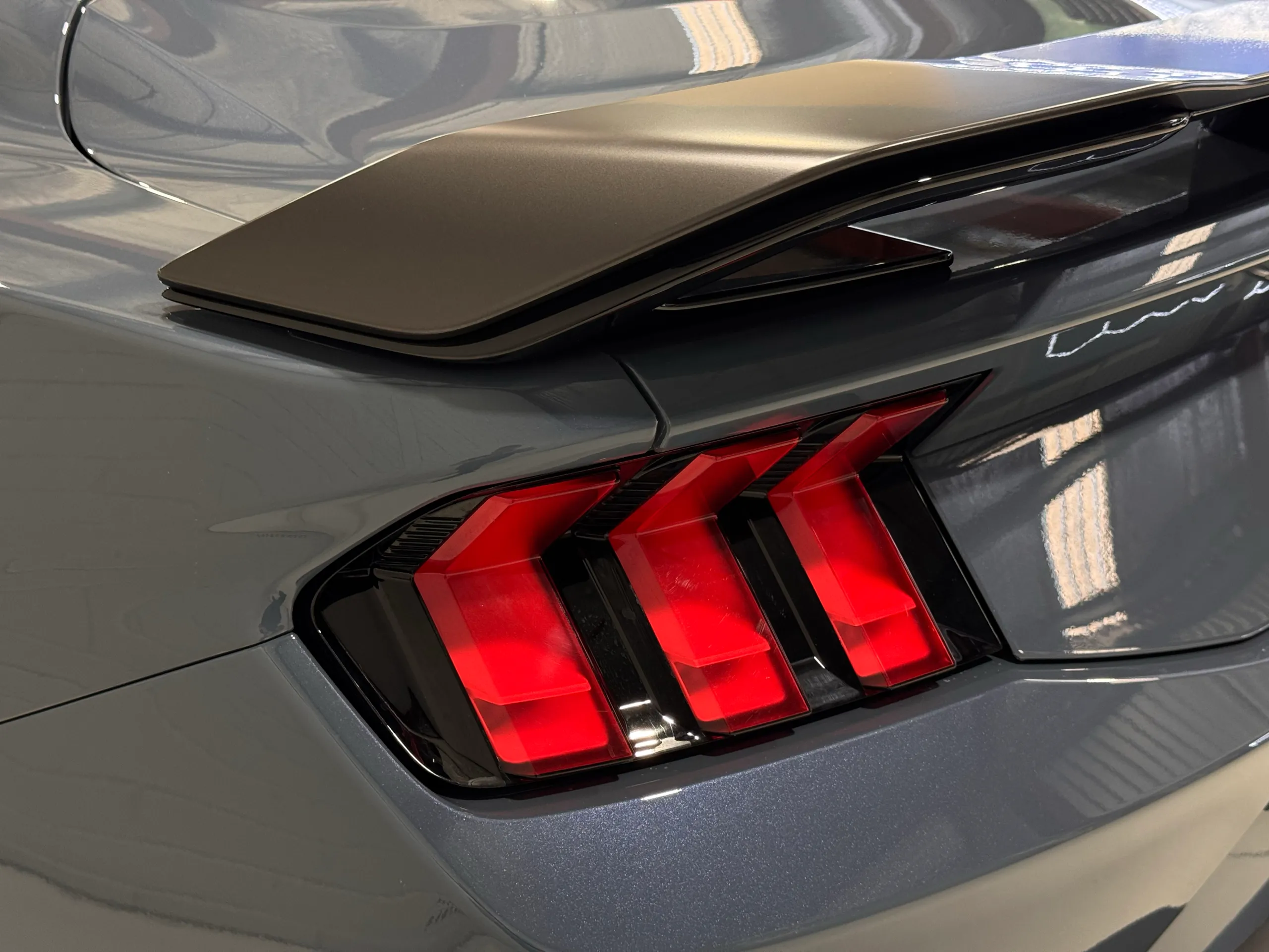 Close-up of the Ford Mustang Dark Horse three-bar rear light beneath the spoiler