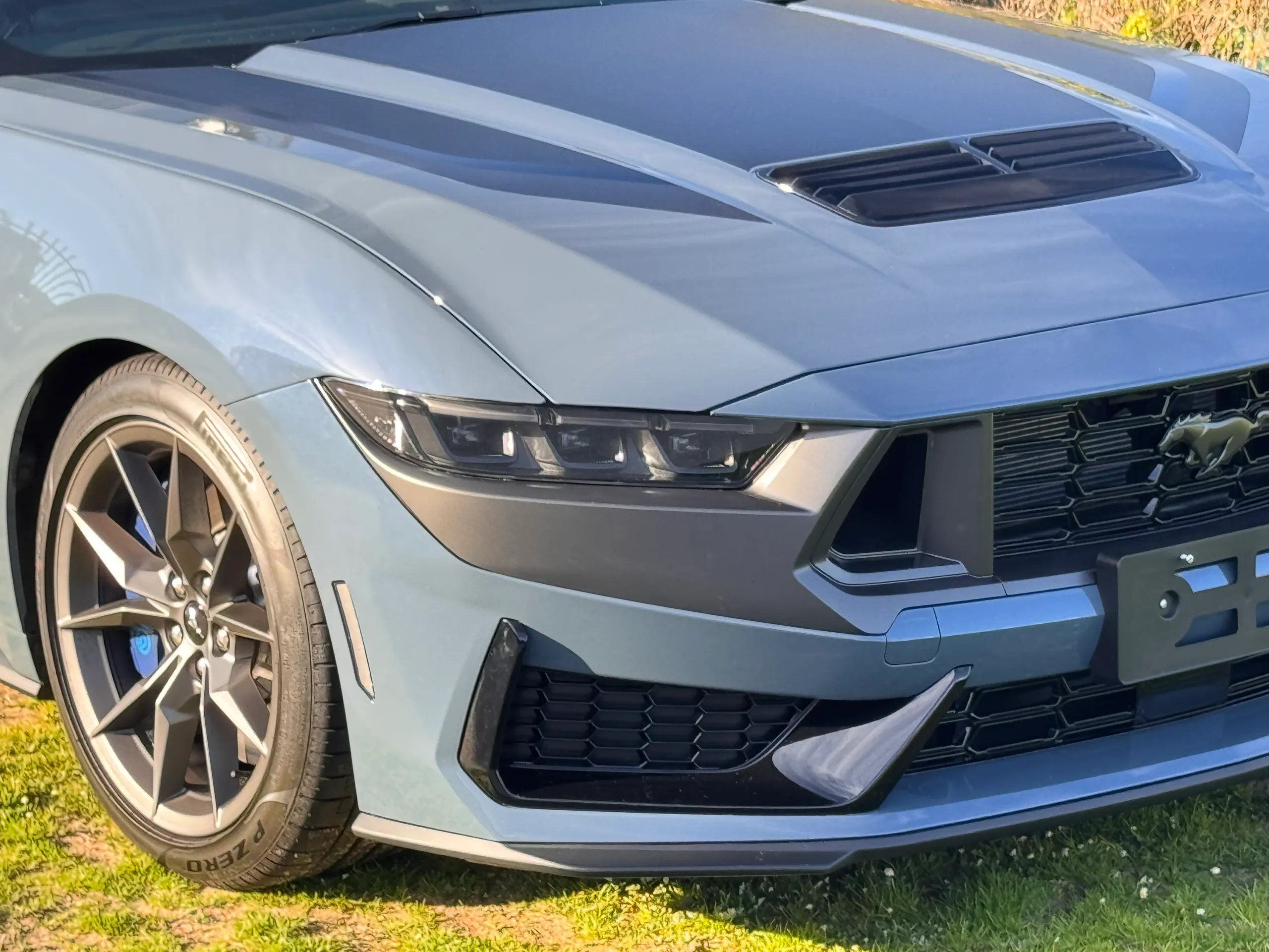 Ford Mustang Dark Horse bonnet graphics, headlight and front wheel outdoors in sunlight