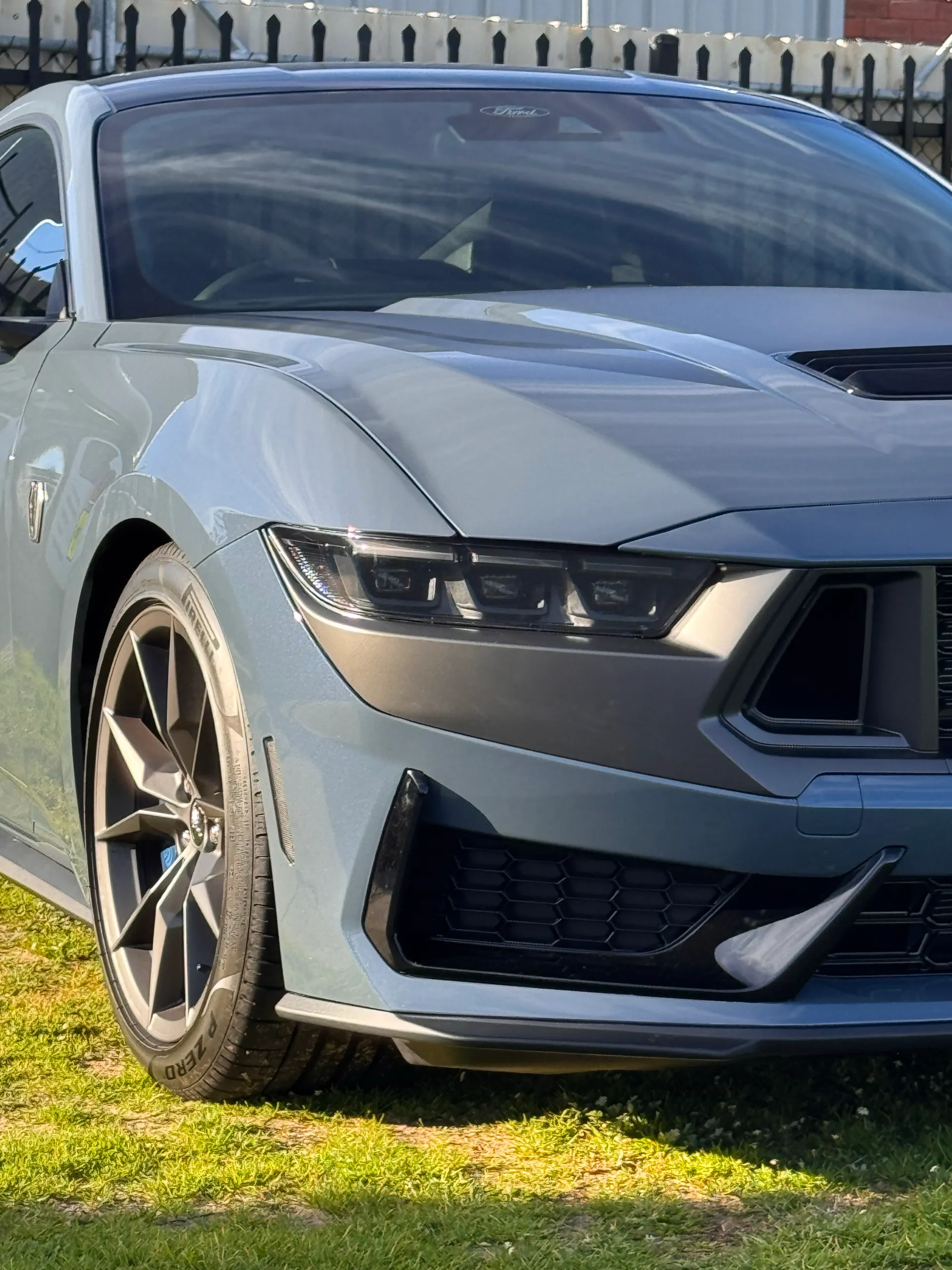 Portrait detail of the gloss blue-grey Ford Mustang Dark Horse front corner outdoors