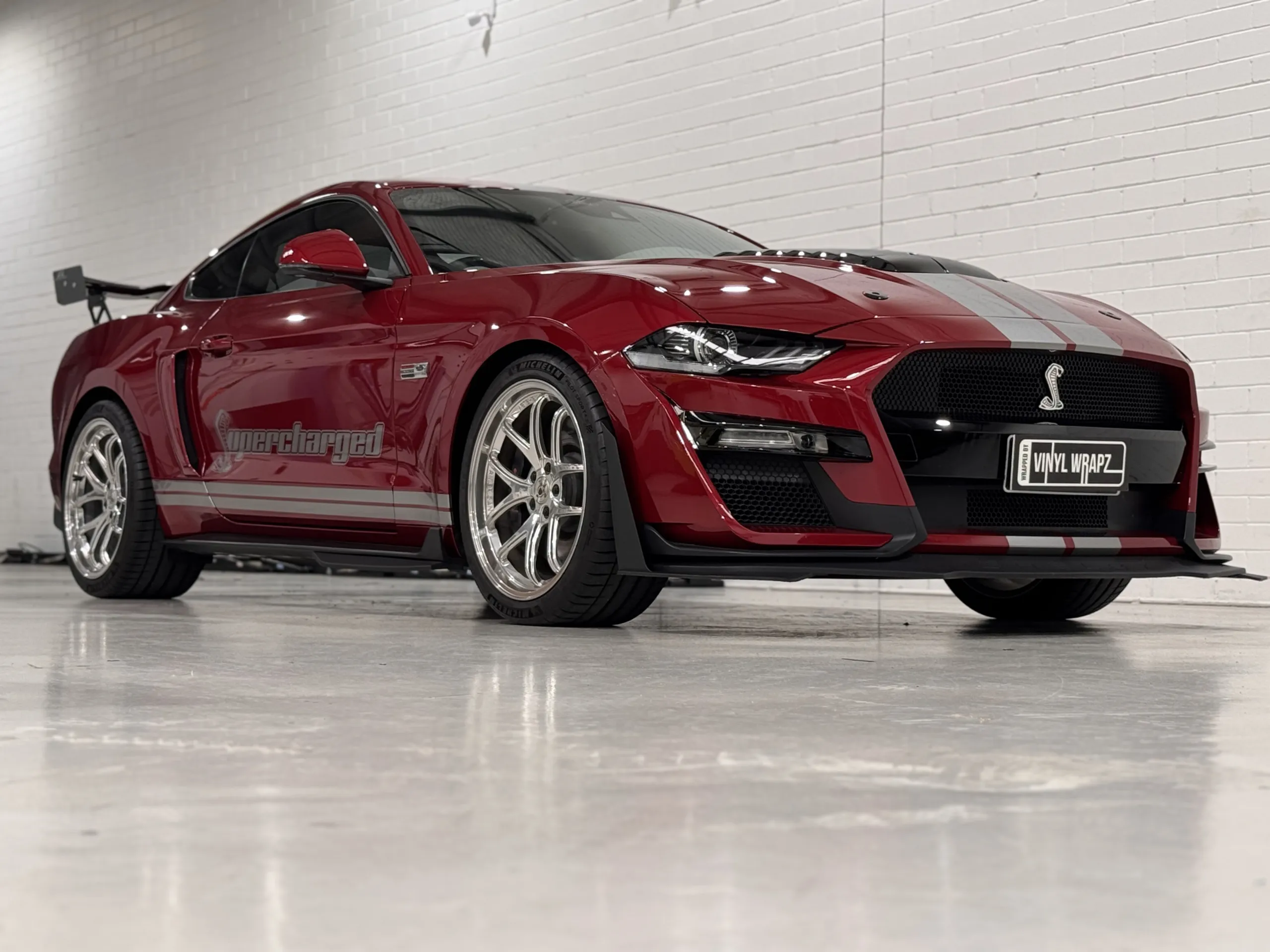 Red Ford Mustang with silver stripes, front quarter