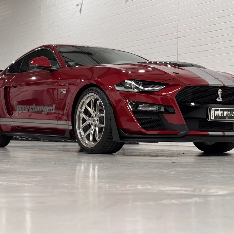 Red Ford Mustang with silver stripes, front quarter