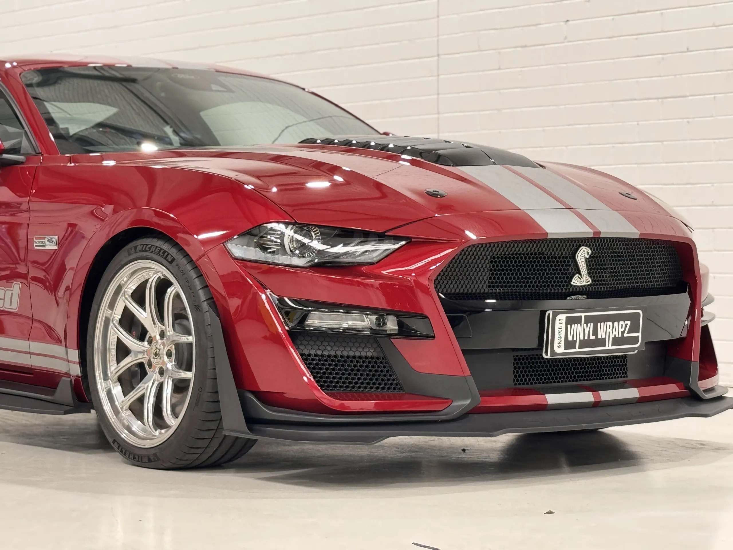 Red Ford Mustang with silver stripes, front quarter