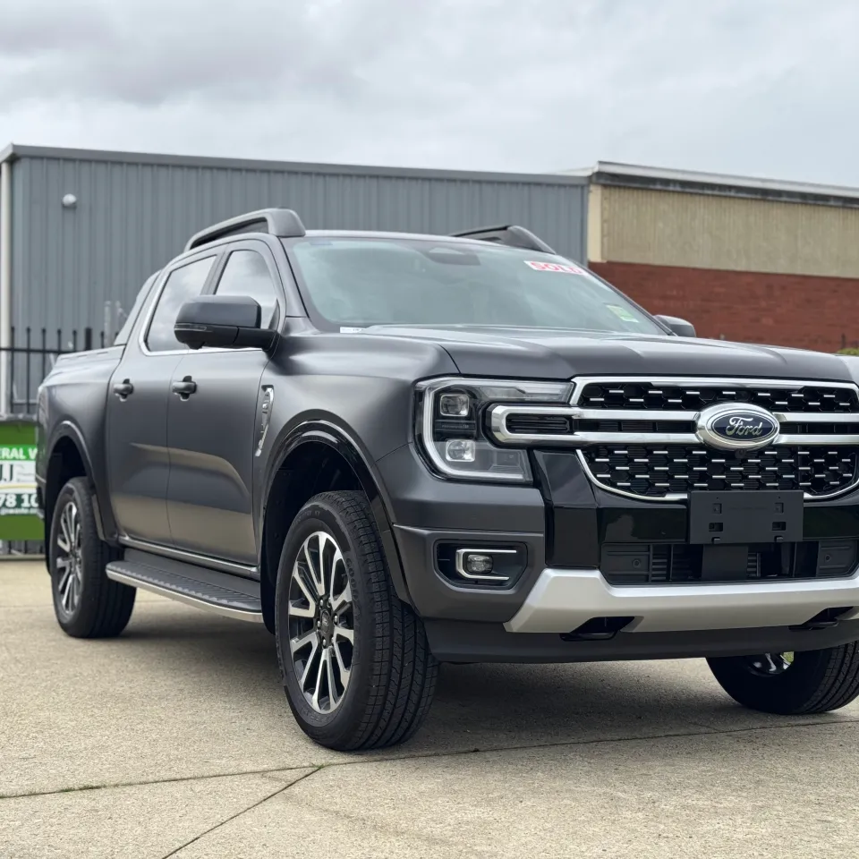 Satin grey Ford Ranger Platinum viewed from the front quarter outside the workshop