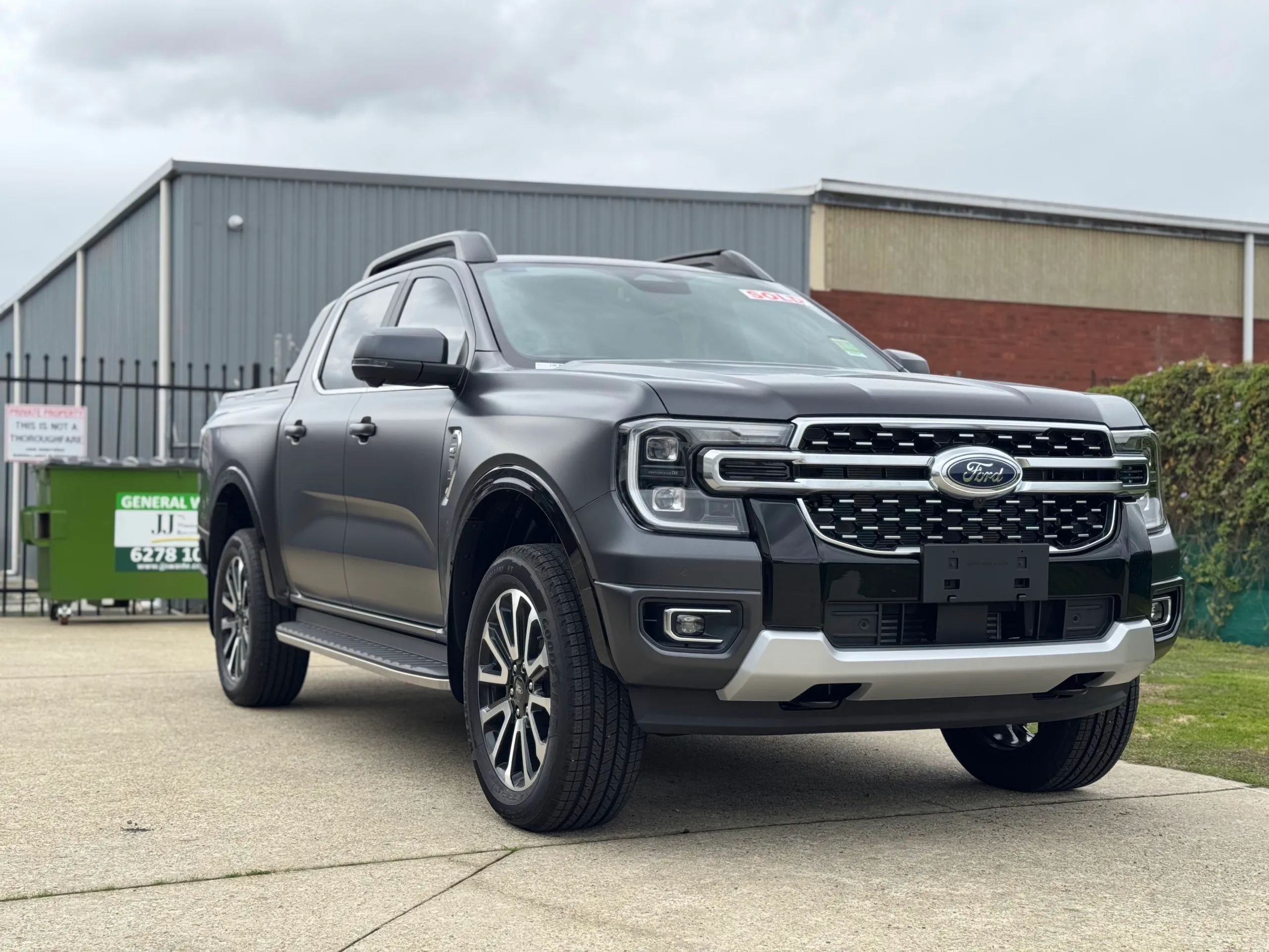 Satin grey Ford Ranger Platinum viewed from the front quarter outside the workshop