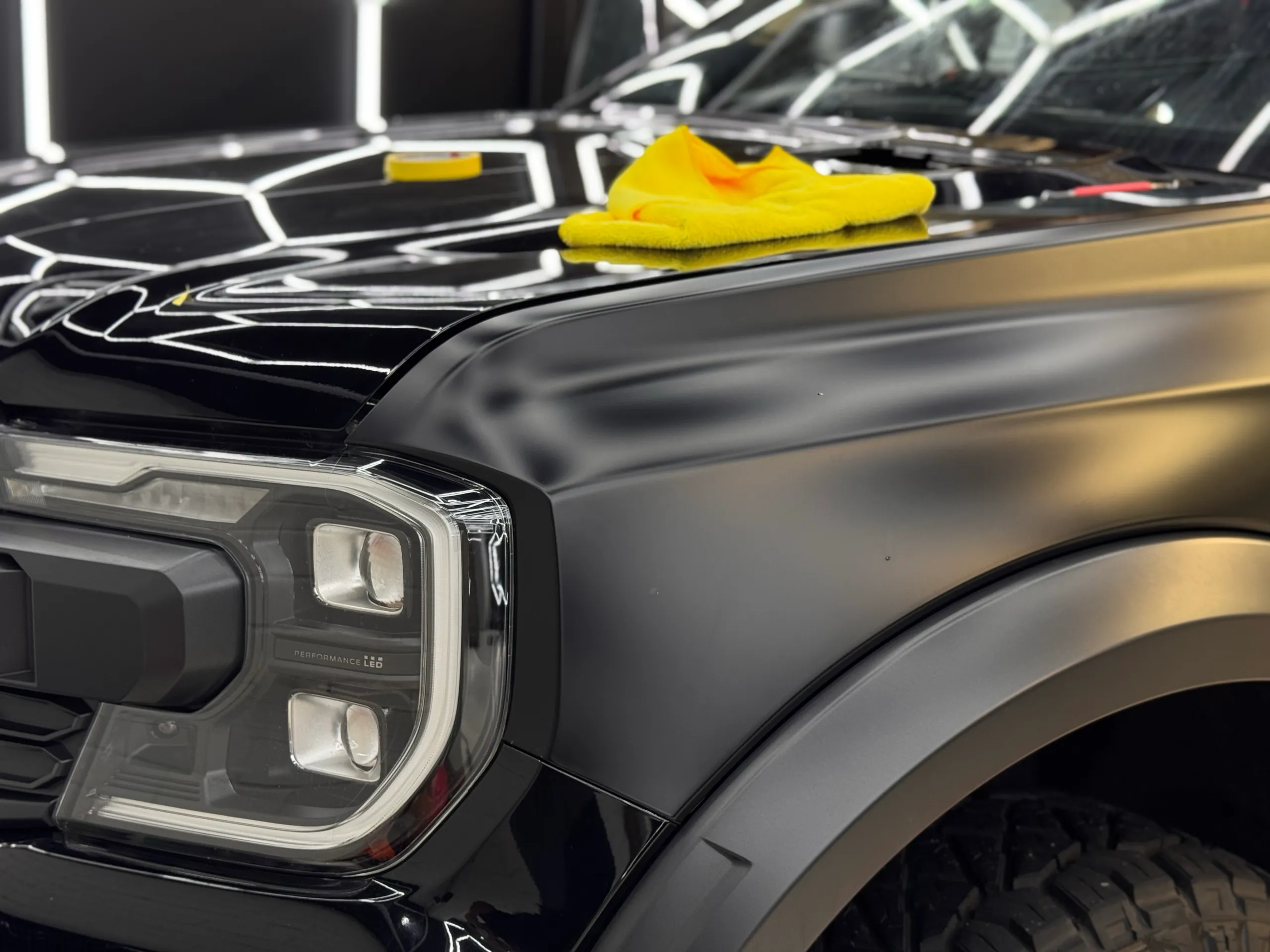 Satin Ranger front guard beside a gloss bonnet with a yellow cloth during workshop preparation