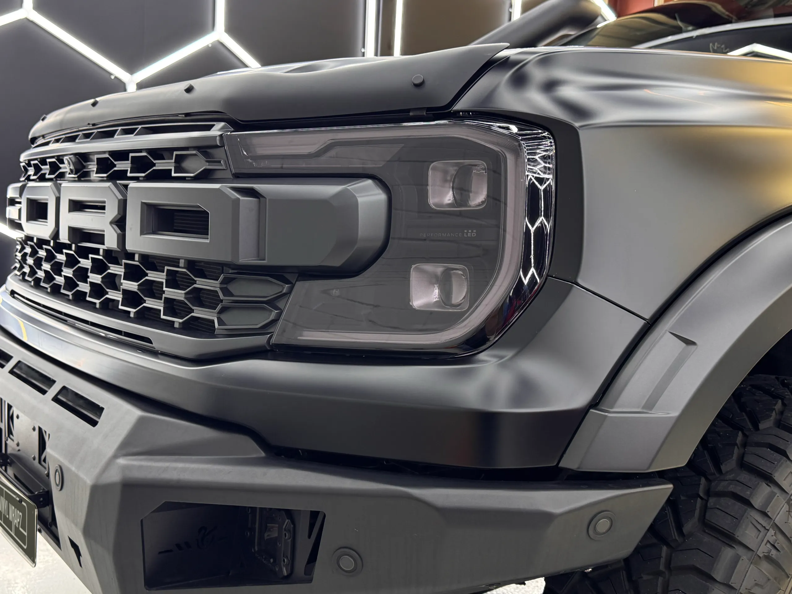 Close view of the Ranger Raptor grille, headlight and satin grey front bodywork