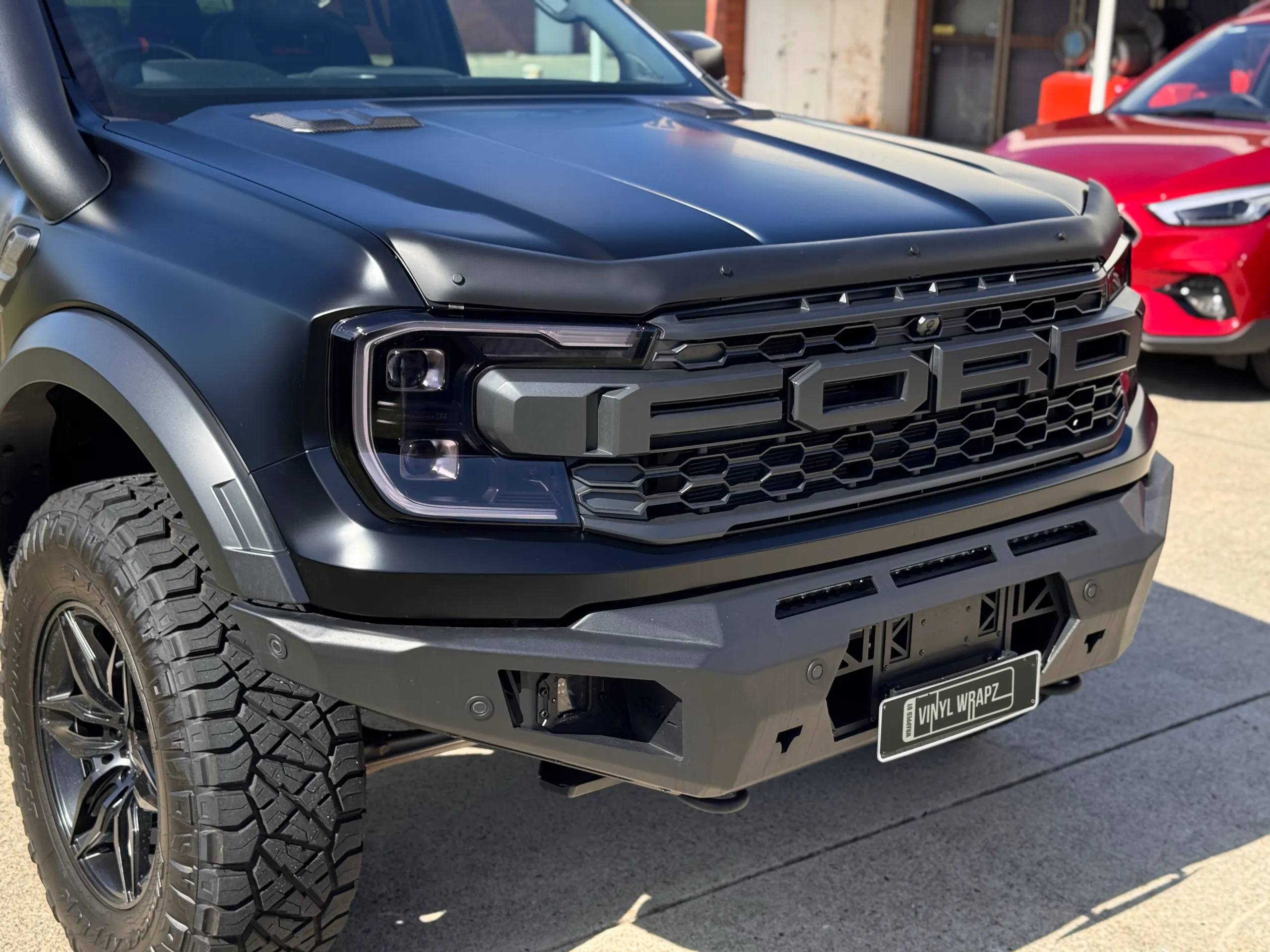 Close view of the Ranger Raptor bonnet, grille and bumper outside the workshop