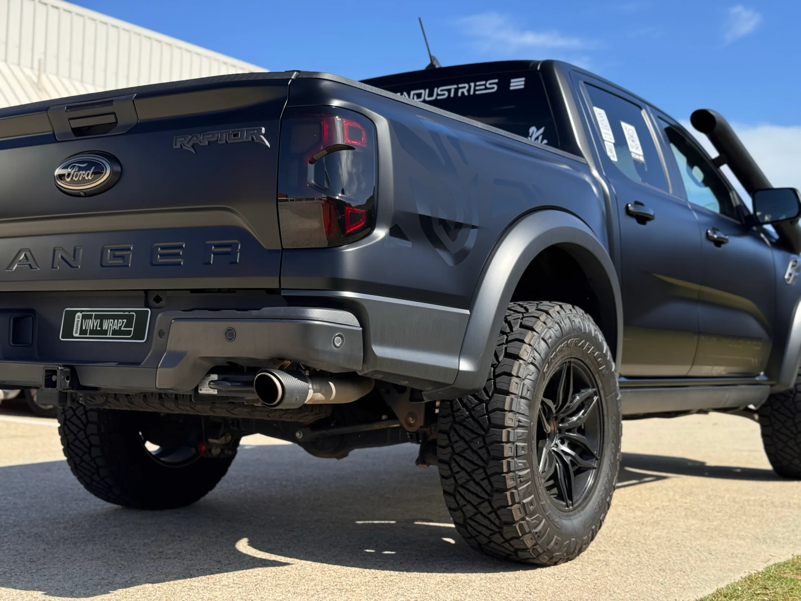 Low rear-quarter view of the satin grey Ranger Raptor tailgate and rear wheel