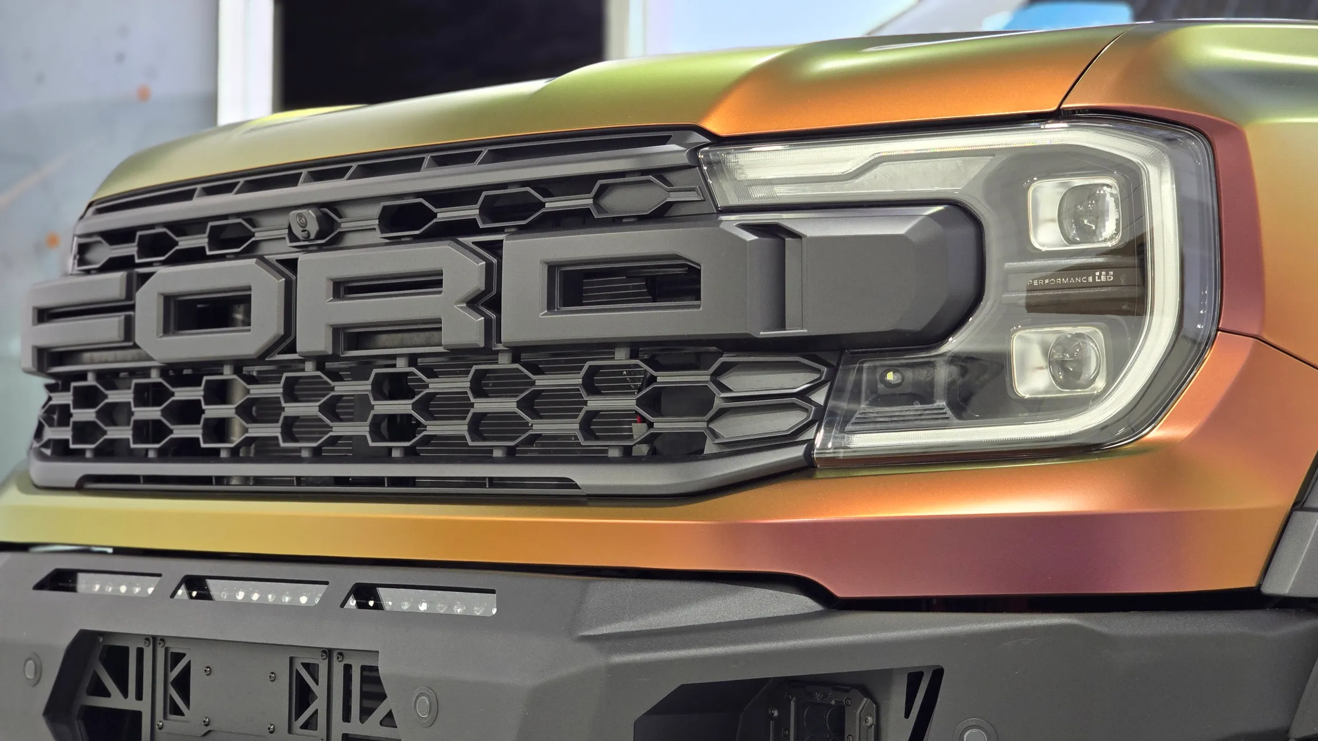 Ford grille and headlight surrounded by gold and copper colour-shift bodywork