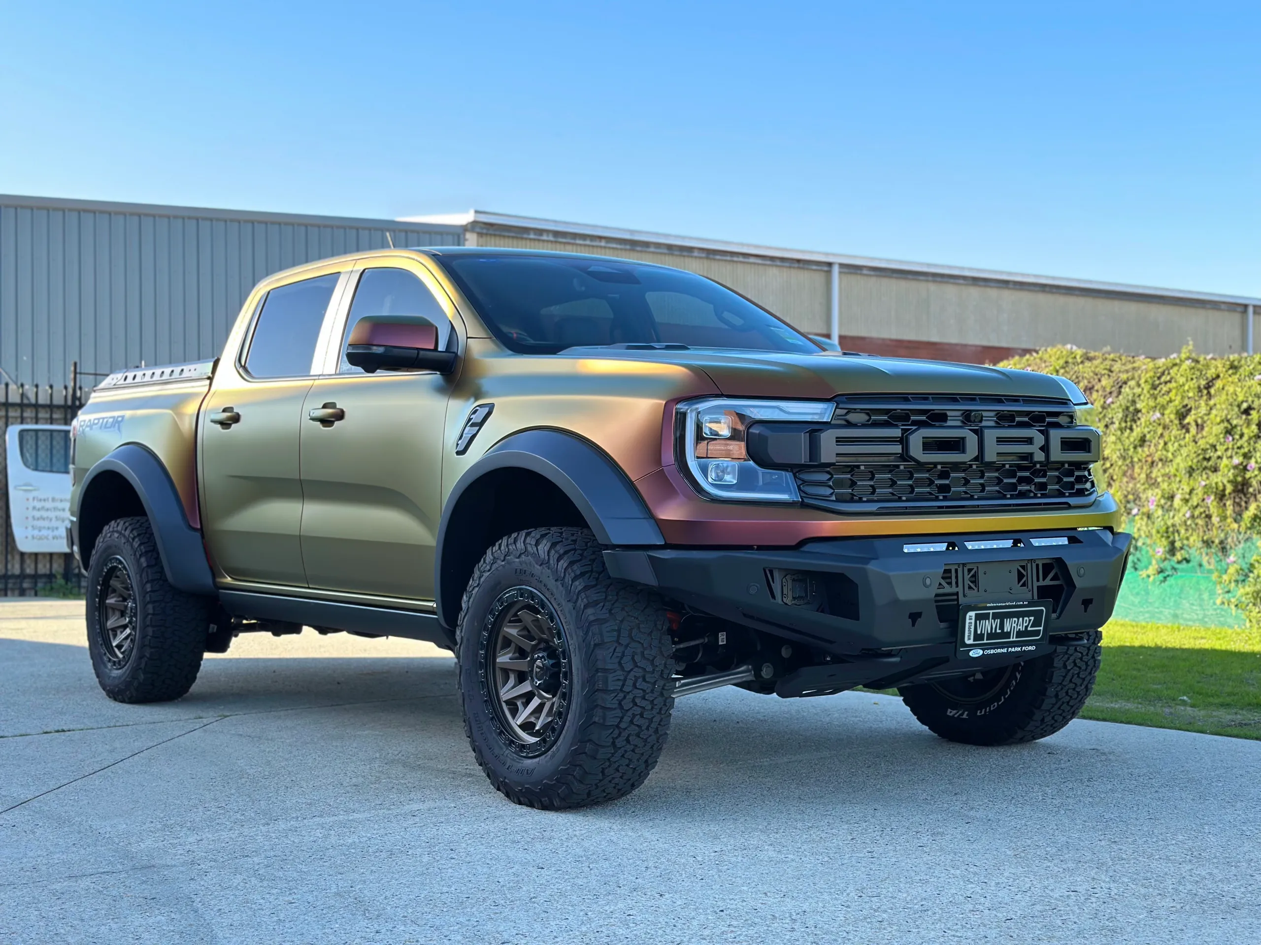 Ford Ranger Raptor with a satin colour-shift wrap, off-road tyres and black front bar outdoors