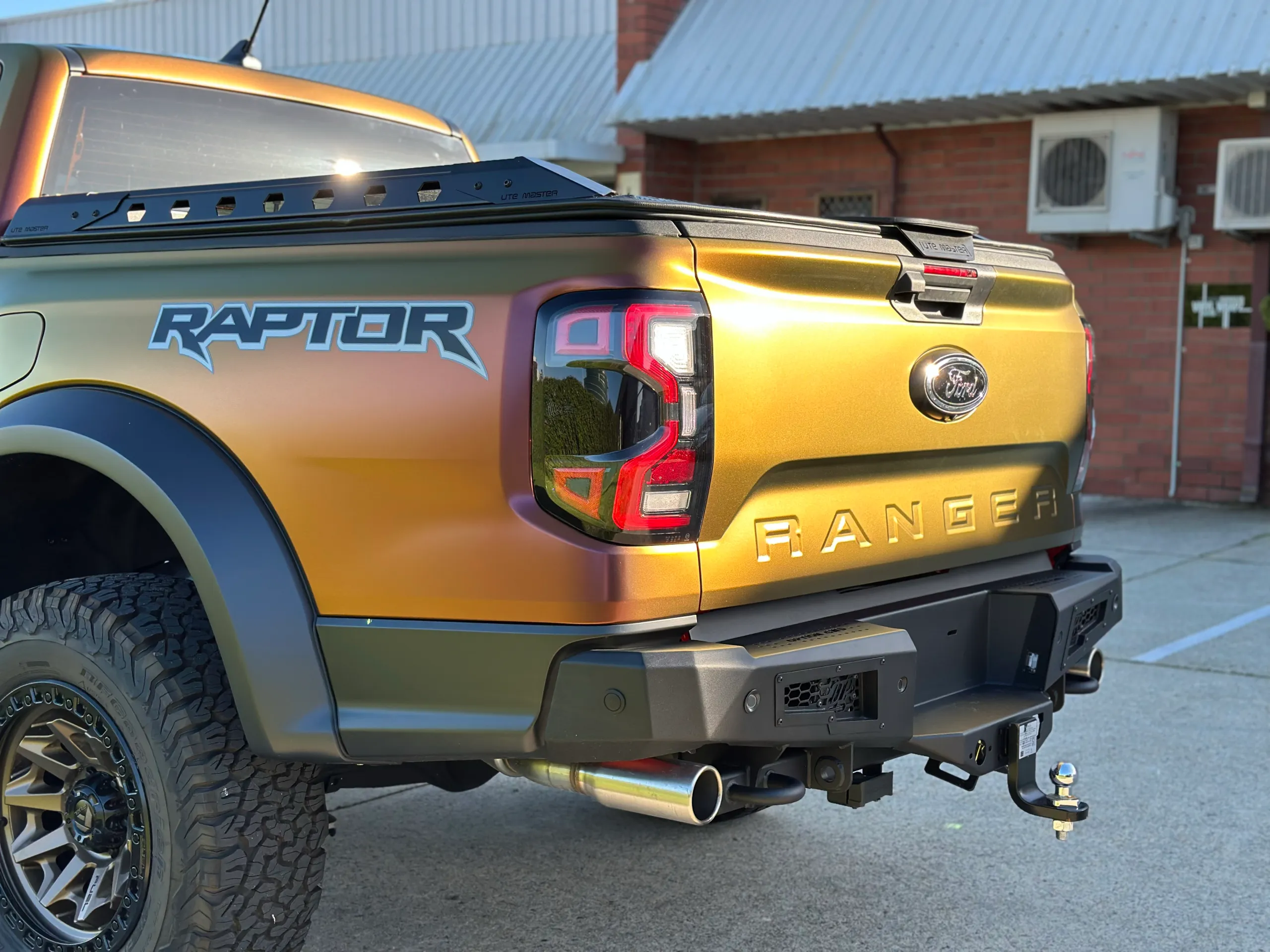 Colour-shift Ford Ranger Raptor rear corner, tailgate and black bumper in sunlight