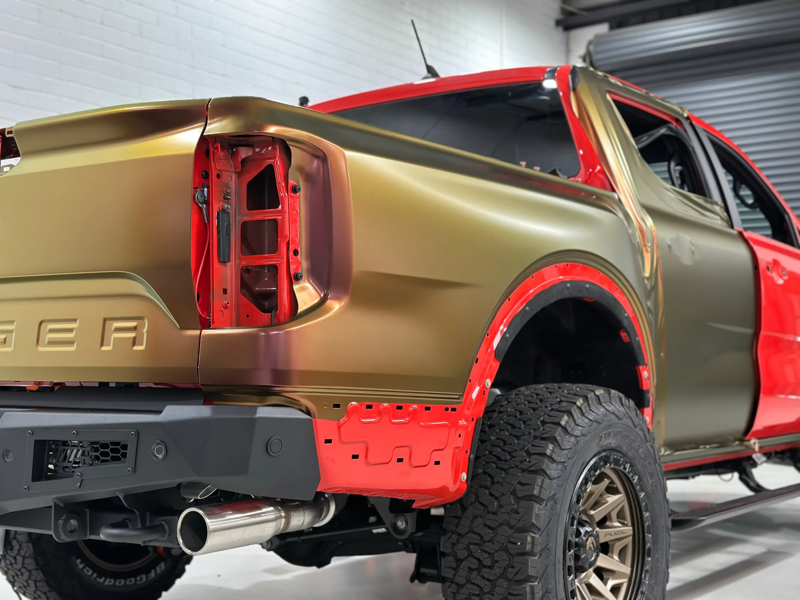 Ford Ranger Raptor rear quarter during colour-change wrapping with the rear light and arch trim removed