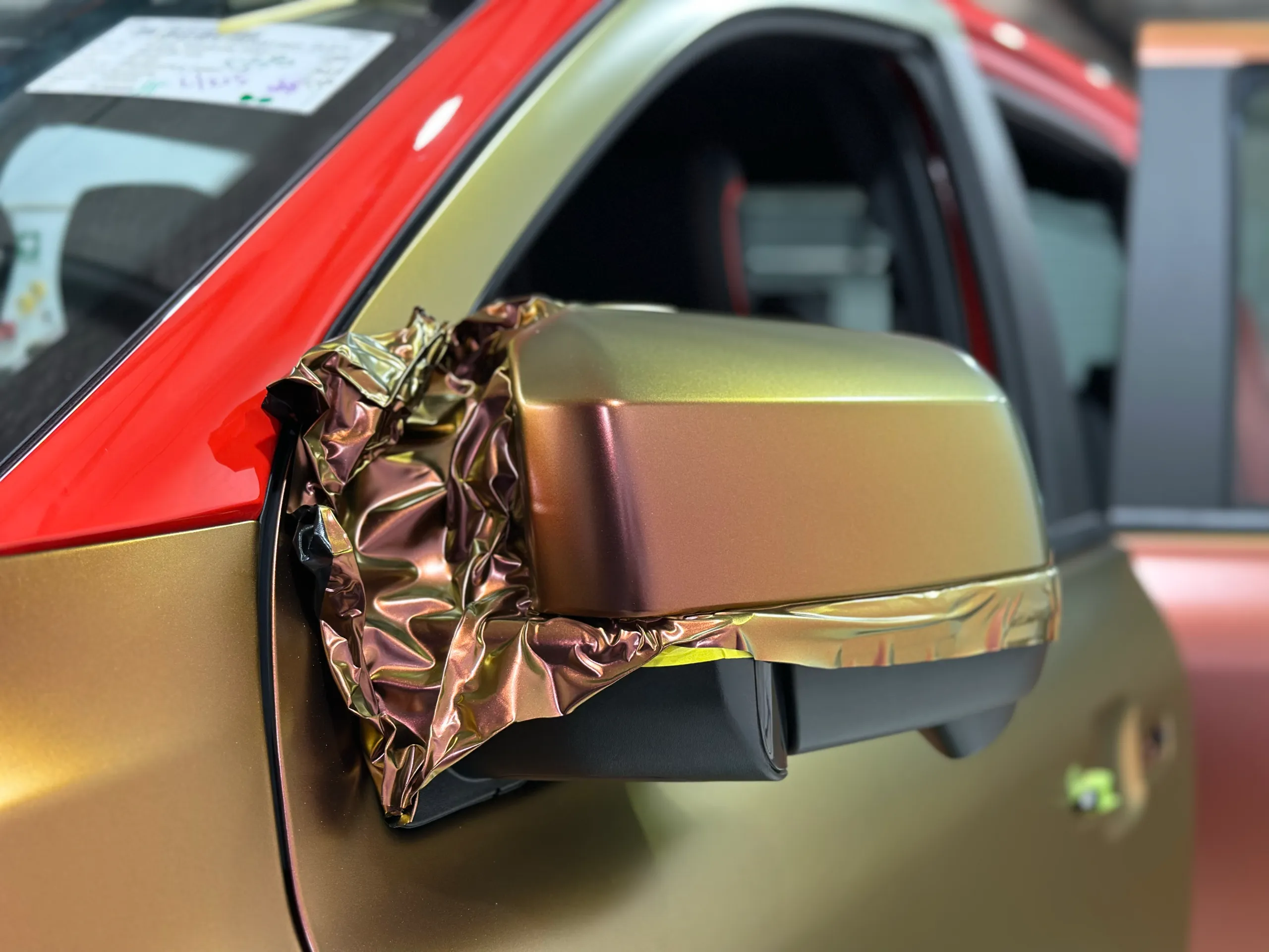 Loose colour-shift film around the Ford Ranger Raptor mirror during installation
