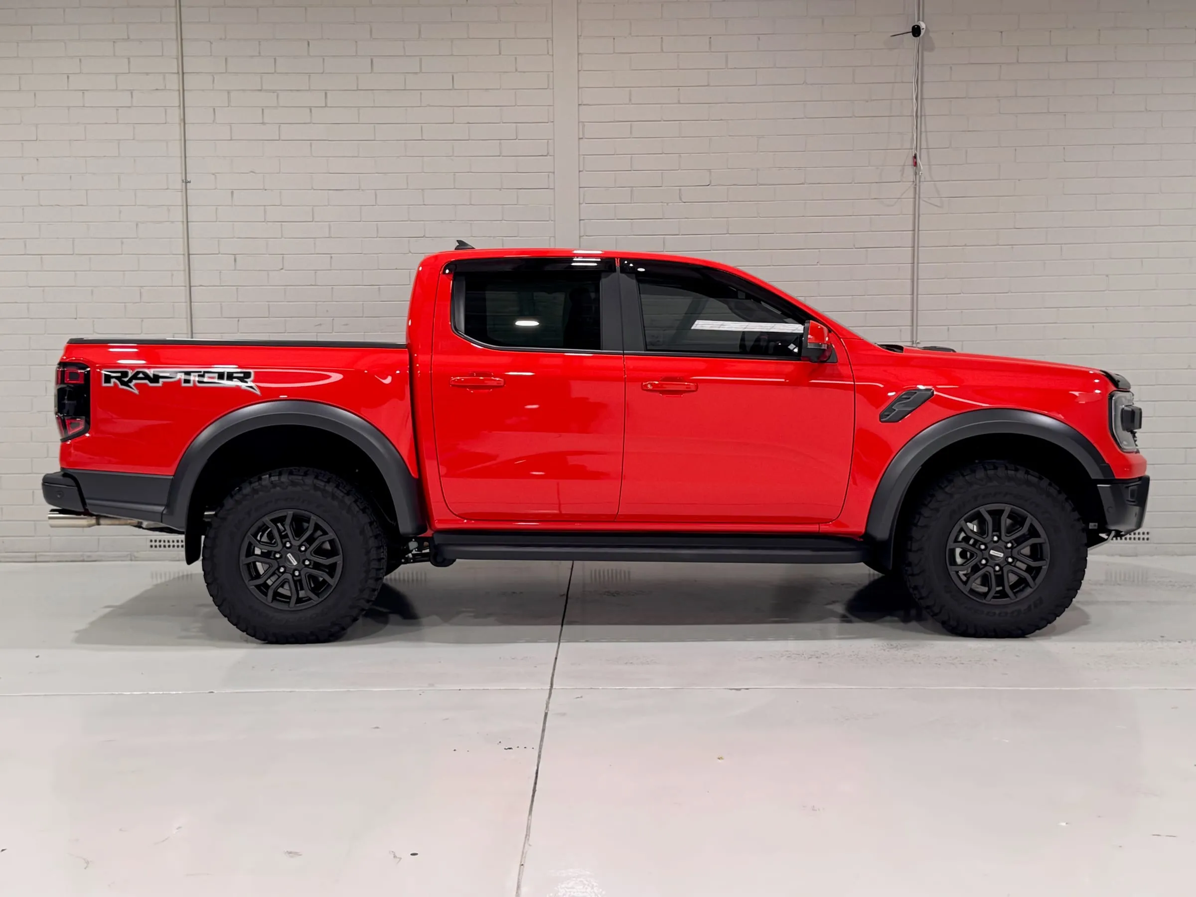 Red Ford Ranger Raptor with clear gloss paint protection film, side profile in the Vinyl Wrapz workshop