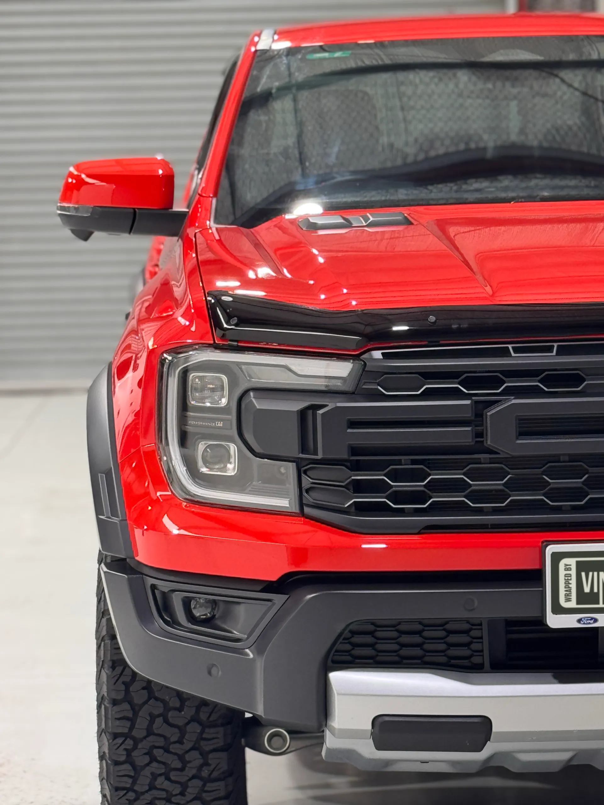 Red Ford Ranger Raptor headlight, black grille and front bumper