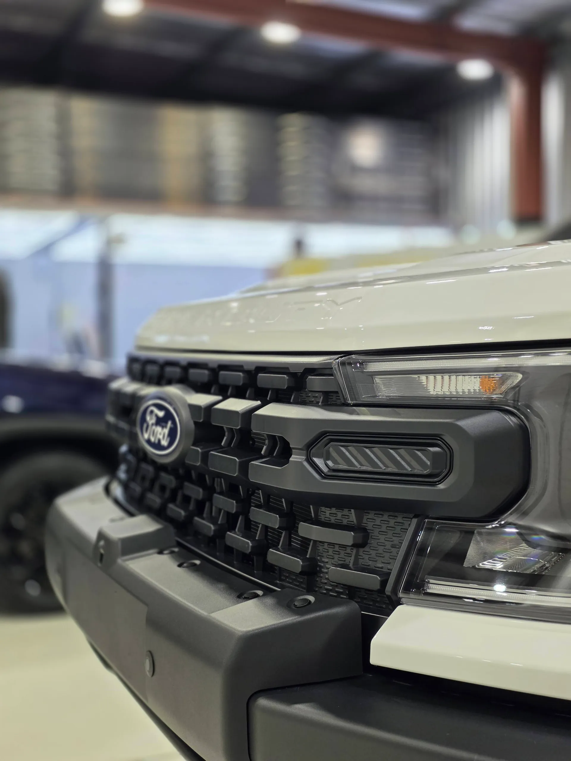 Ford badge and grille on the white Ranger Super Duty in the workshop