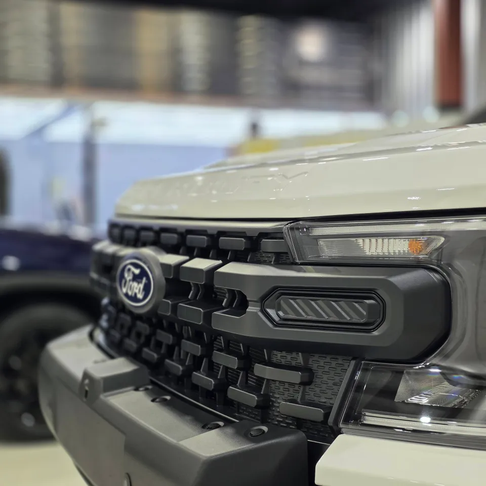 Ford badge and grille on the white Ranger Super Duty in the workshop