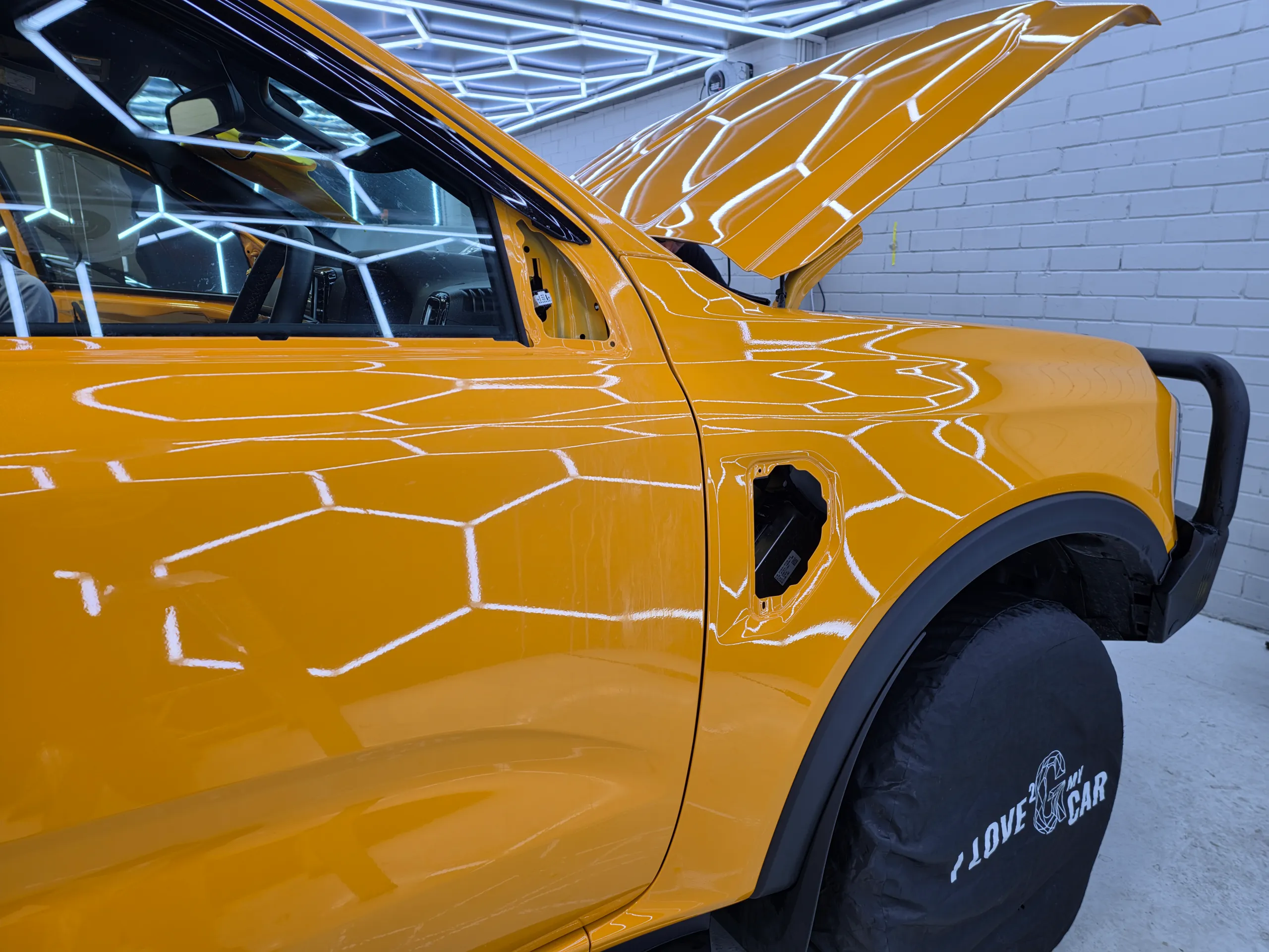 Orange Ford Ranger front door and guard during preparation, with the mirror and guard trim removed