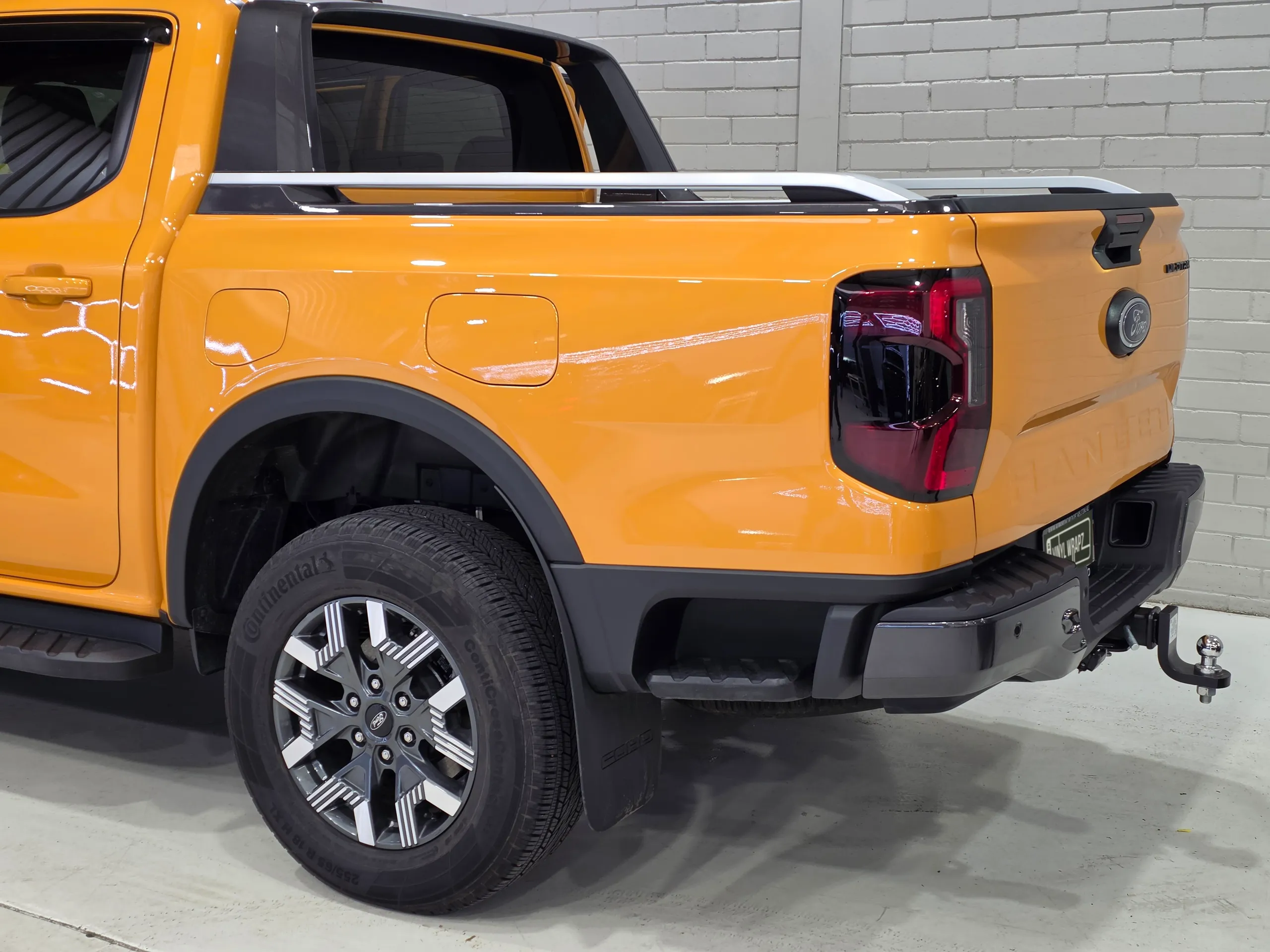 Orange Ford Ranger Wildtrak PHEV rear wheel, tub side and bumper in the workshop