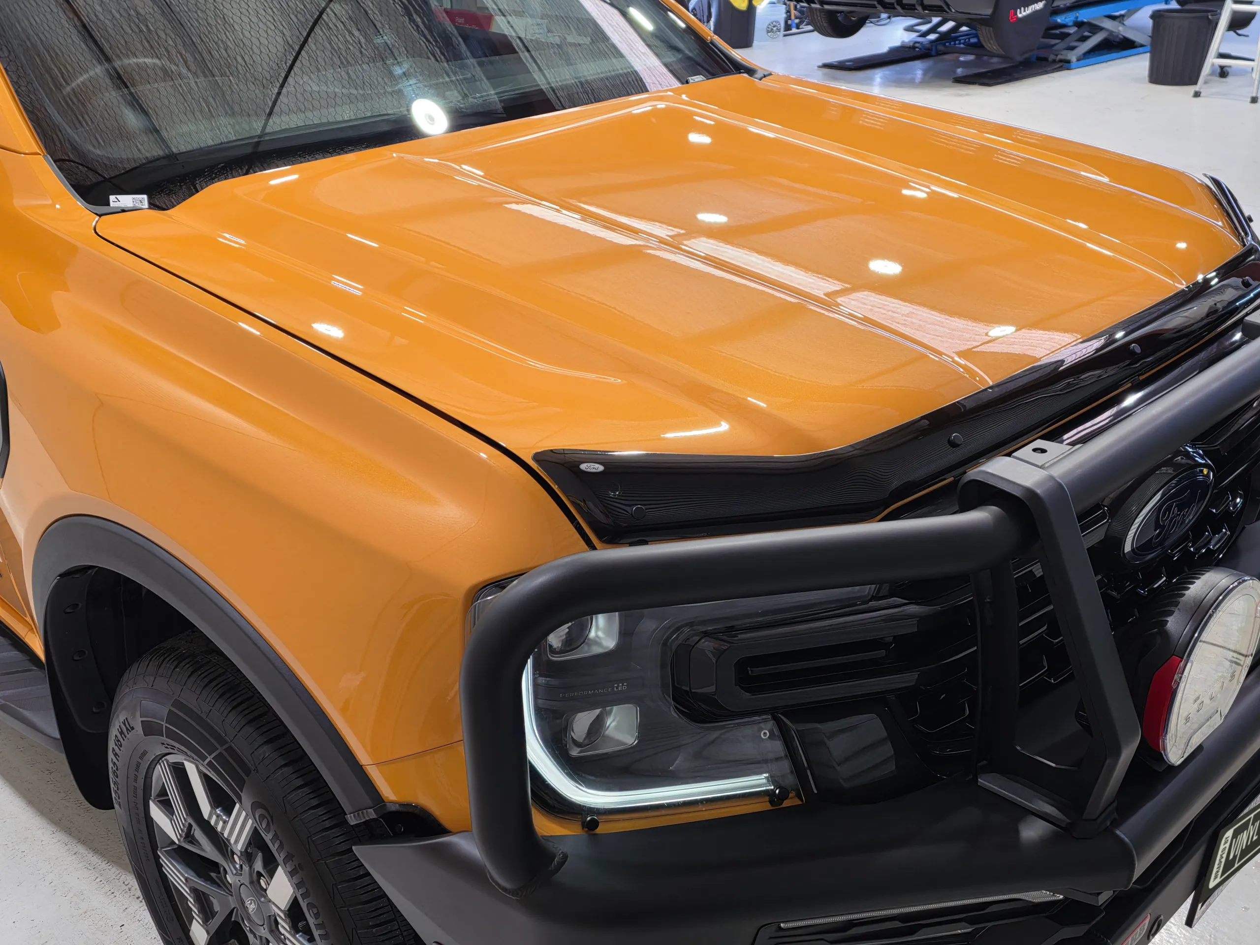Elevated view of the orange Ford Ranger bonnet, front guard and bull bar