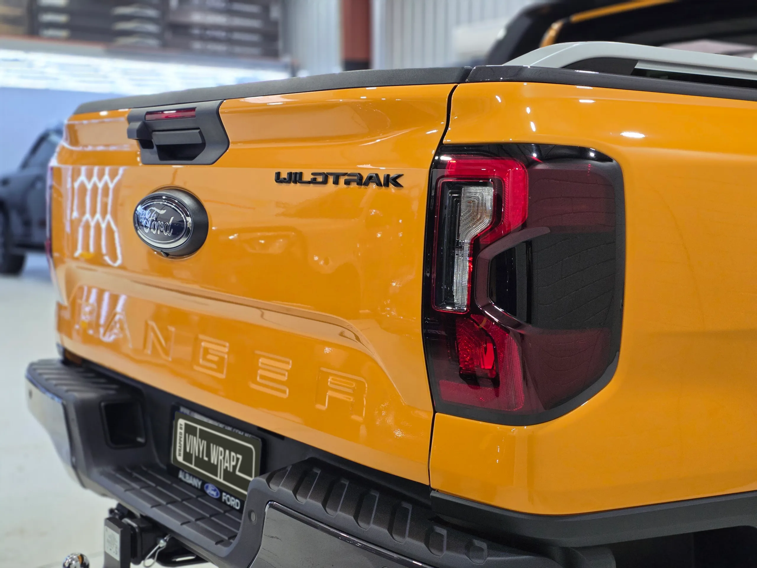 Orange Ford Ranger tailgate and rear light, showing the Wildtrak badge and Ford emblem