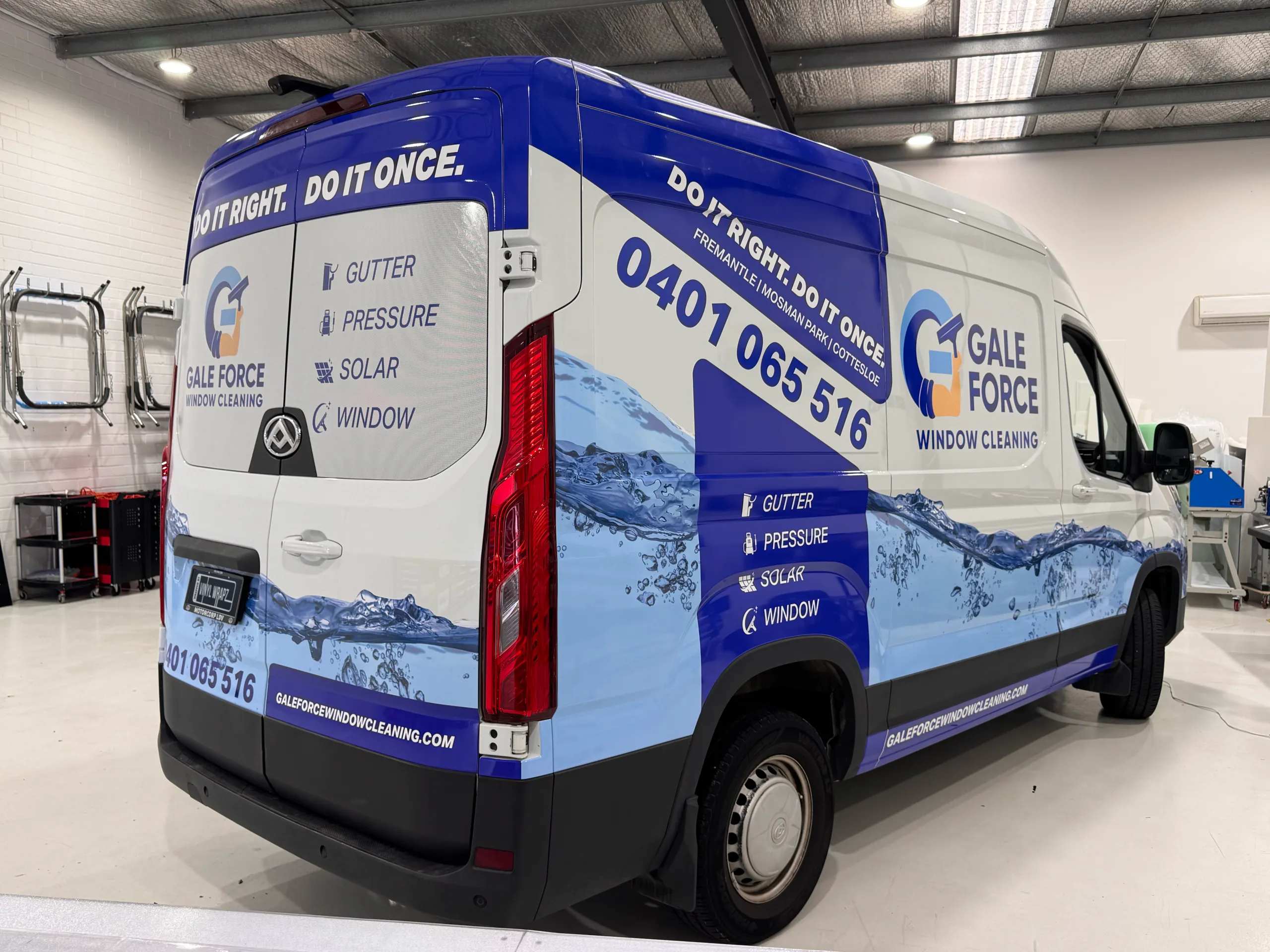 Rear quarter of an LDV van with blue and white Gale Force Window Cleaning graphics in the workshop
