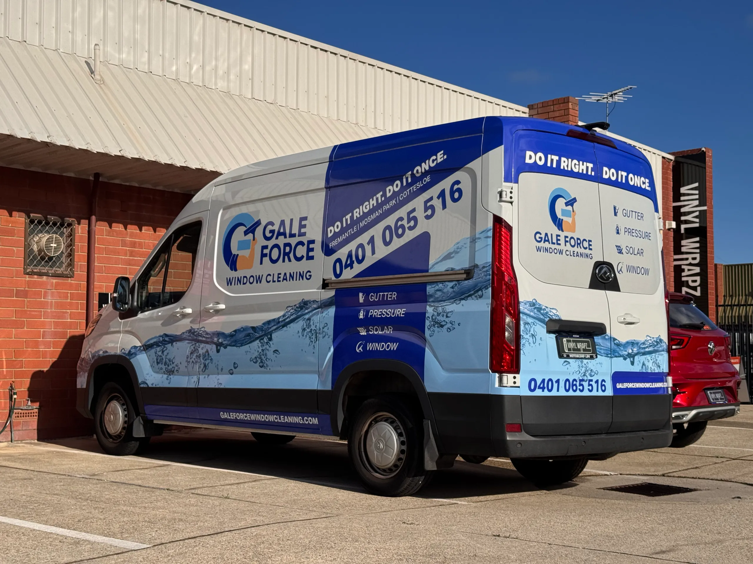 Blue and white Gale Force Window Cleaning van parked outside beside a brick wall