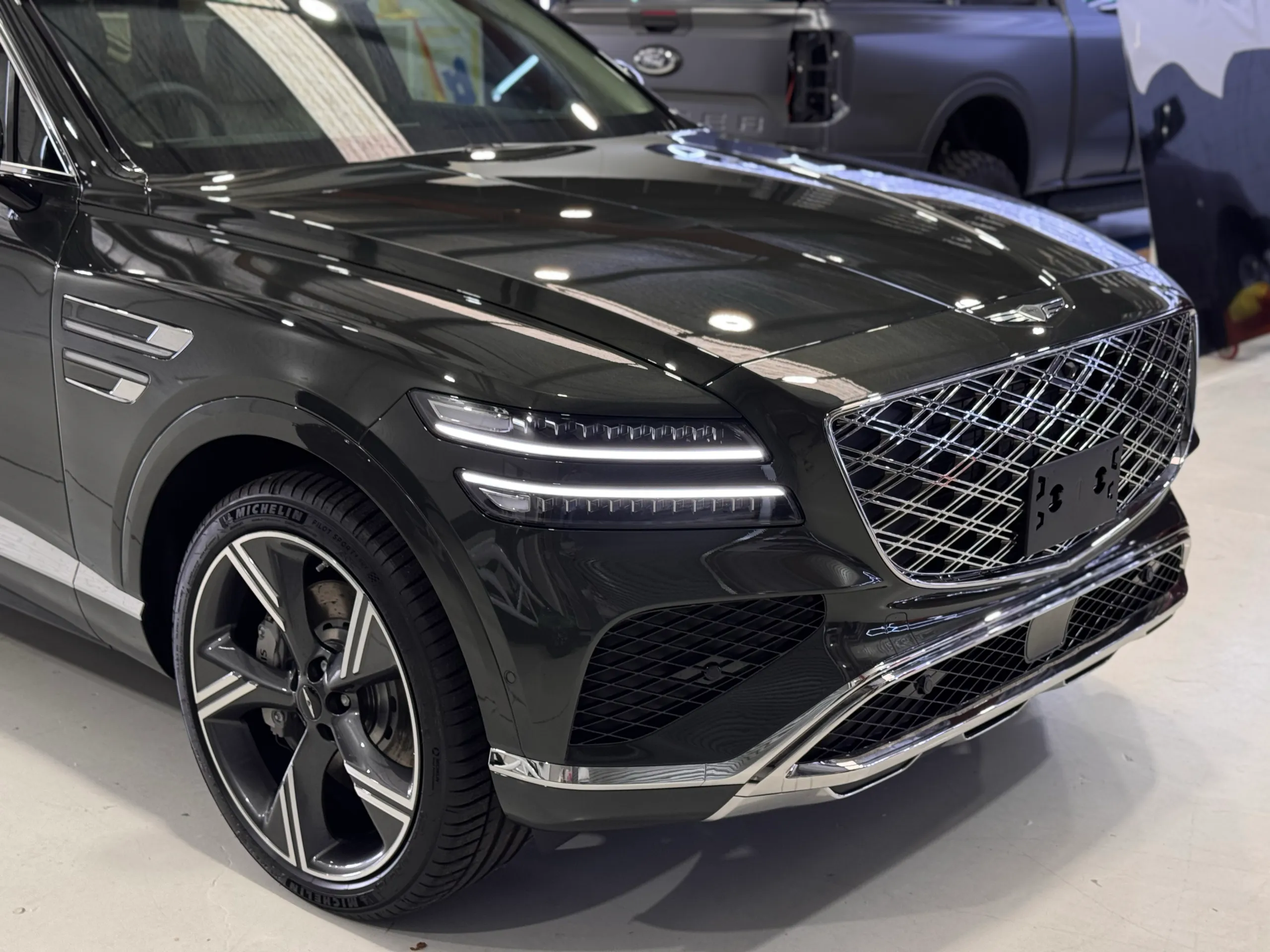 Genesis GV80 front wheel, headlight and grille with gloss dark bodywork