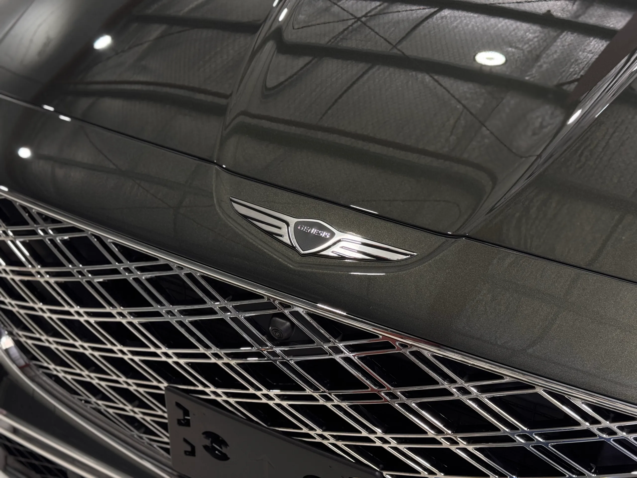 Genesis wing badge on the glossy bonnet above the GV80 grille