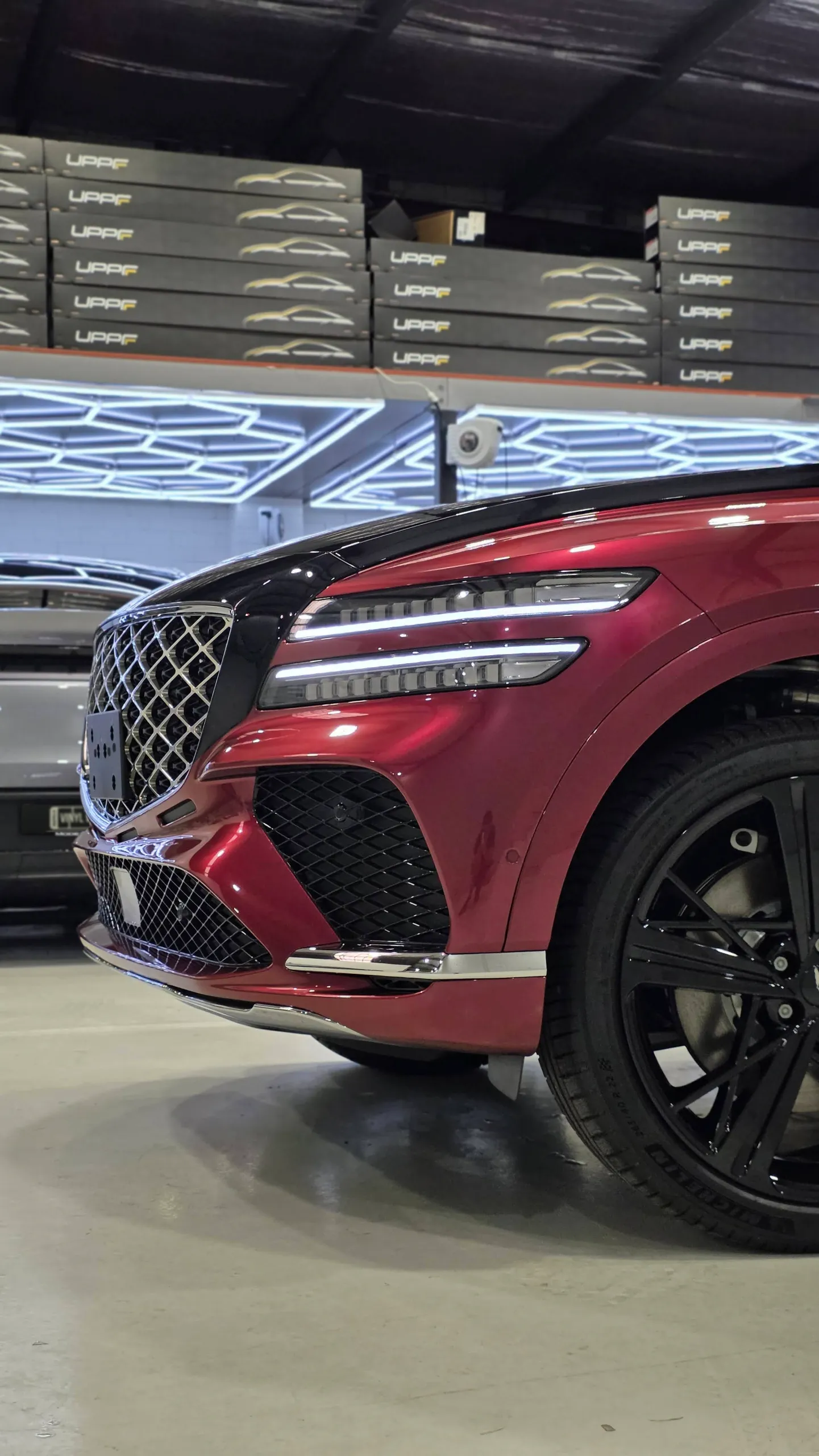 Red Genesis GV80 Coupe front bumper, headlight and black wheel in the workshop