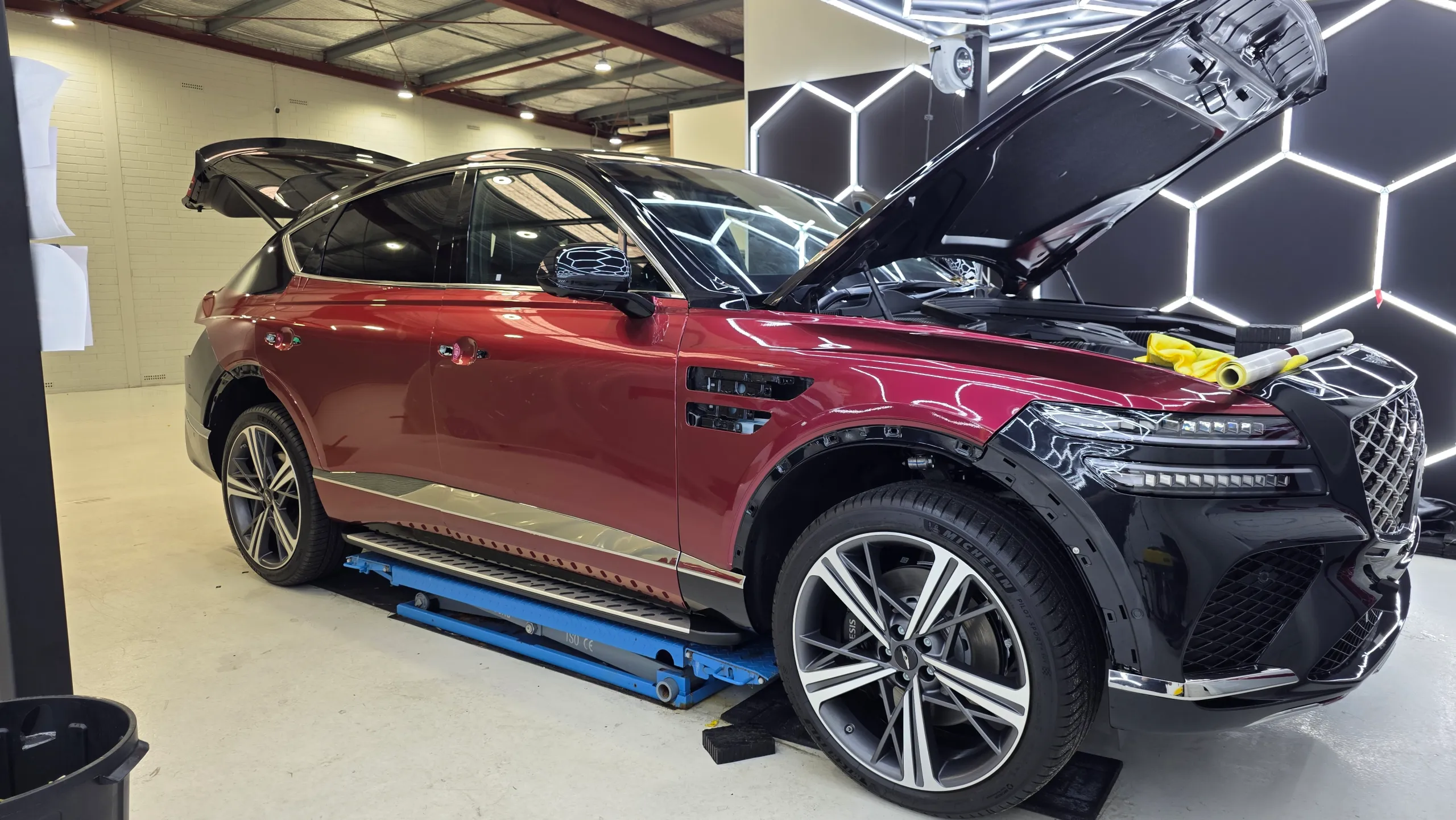 Genesis GV80 Coupe during colour-change work, with bonnet open and trim removed