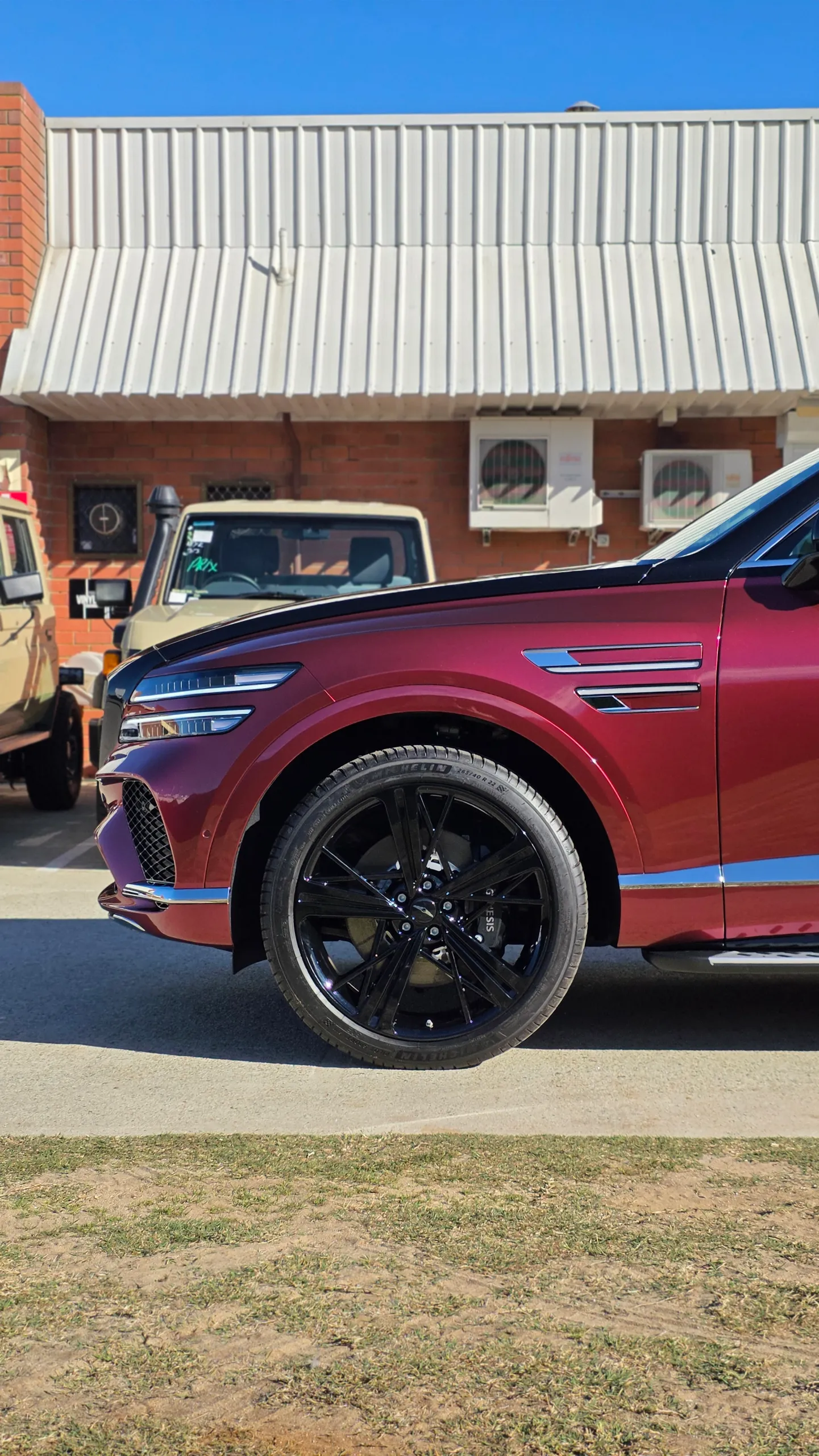 Black front wheel and red front guard of the Genesis GV80 Coupe outdoors