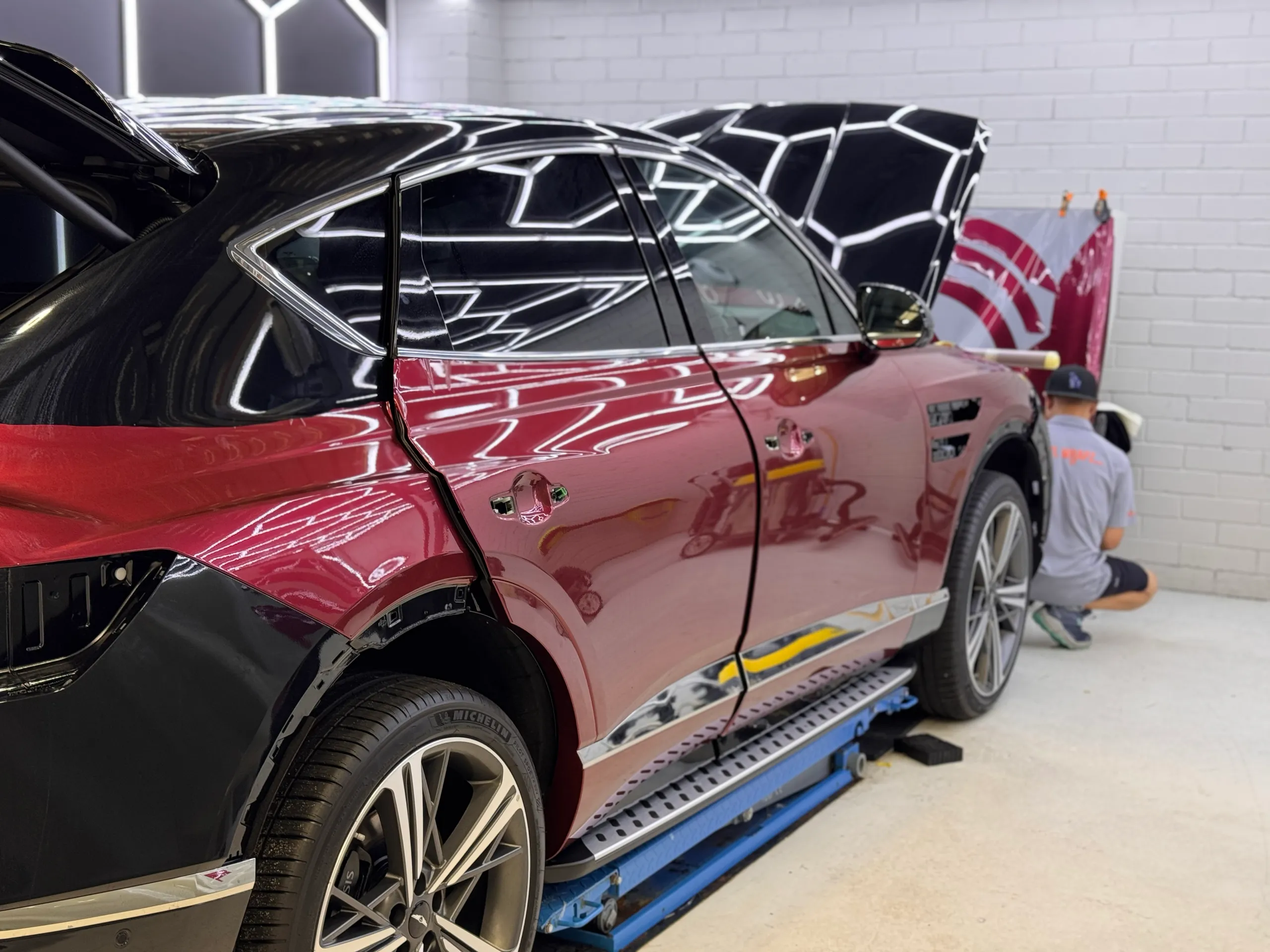 Genesis GV80 Coupe during installation, with door handles removed and an installer facing away
