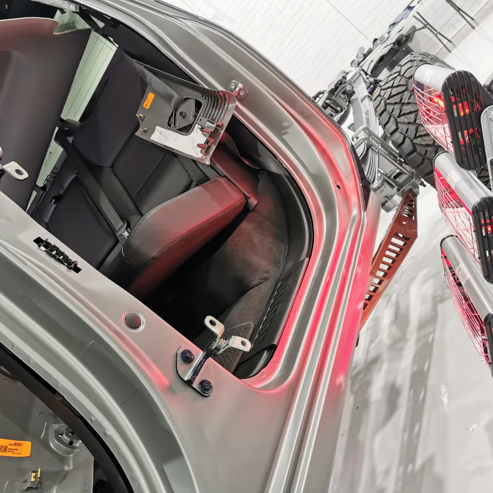 Infrared lamps heating grey film around the GMC cab opening with the doors removed