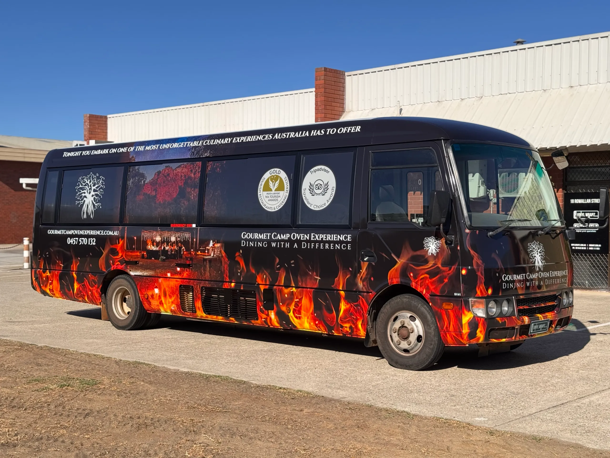 Gourmet Camp Oven Experience branding and flame graphics across the bus side and front