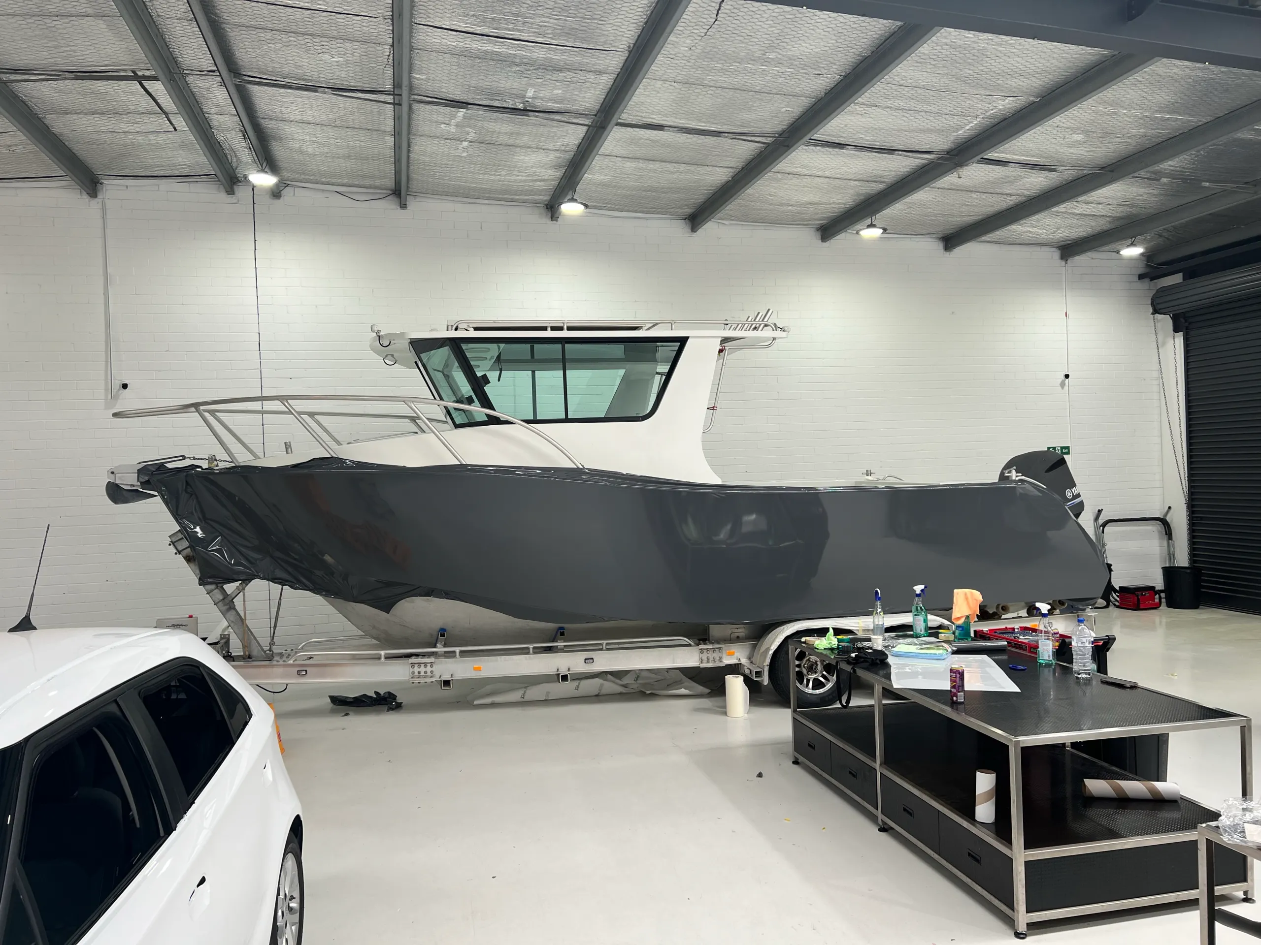 Grey film draped along the aluminium boat hull during installation