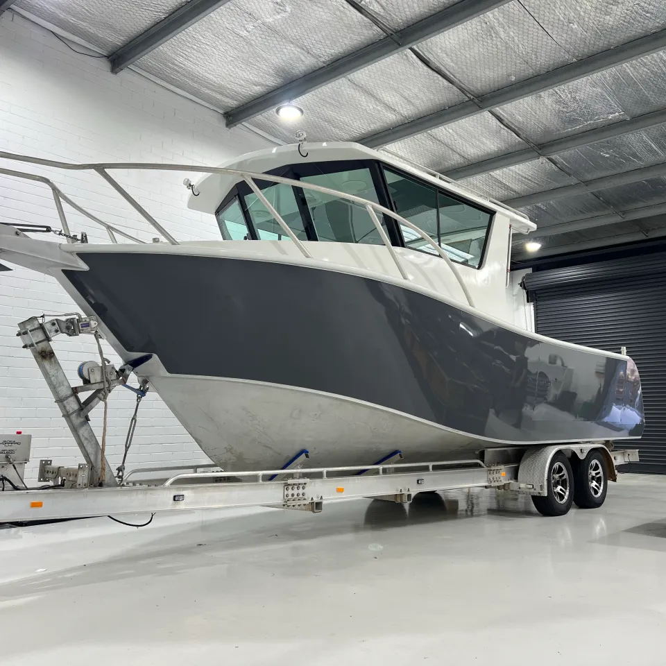 Finished grey hull and white cabin on the aluminium boat in the workshop