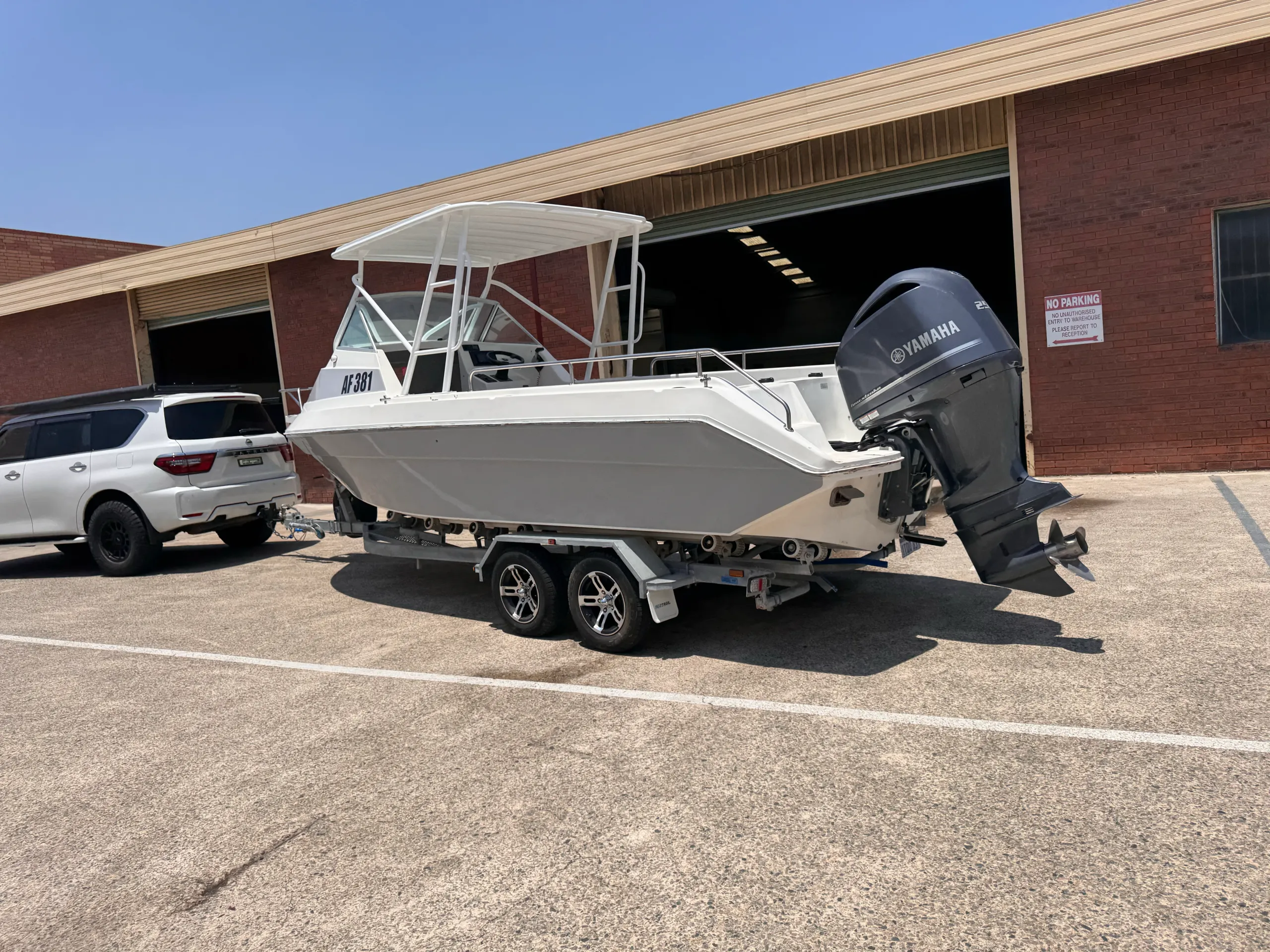 Grey wrapped boat on its trailer with a Yamaha outboard, viewed from the stern quarter